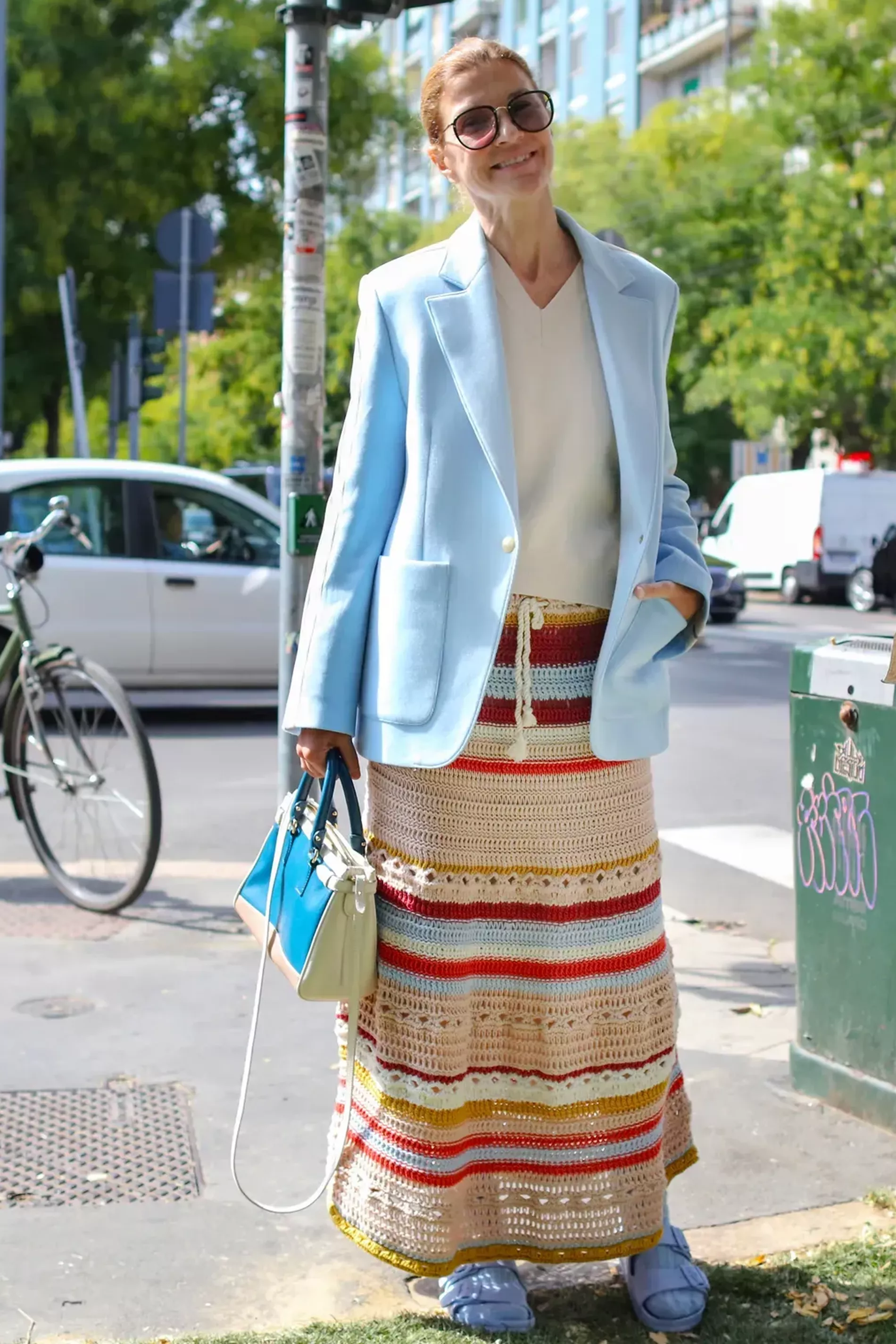 Milan fashion week guest wears striped crochet skirt with baby blue blazer and cream sweater