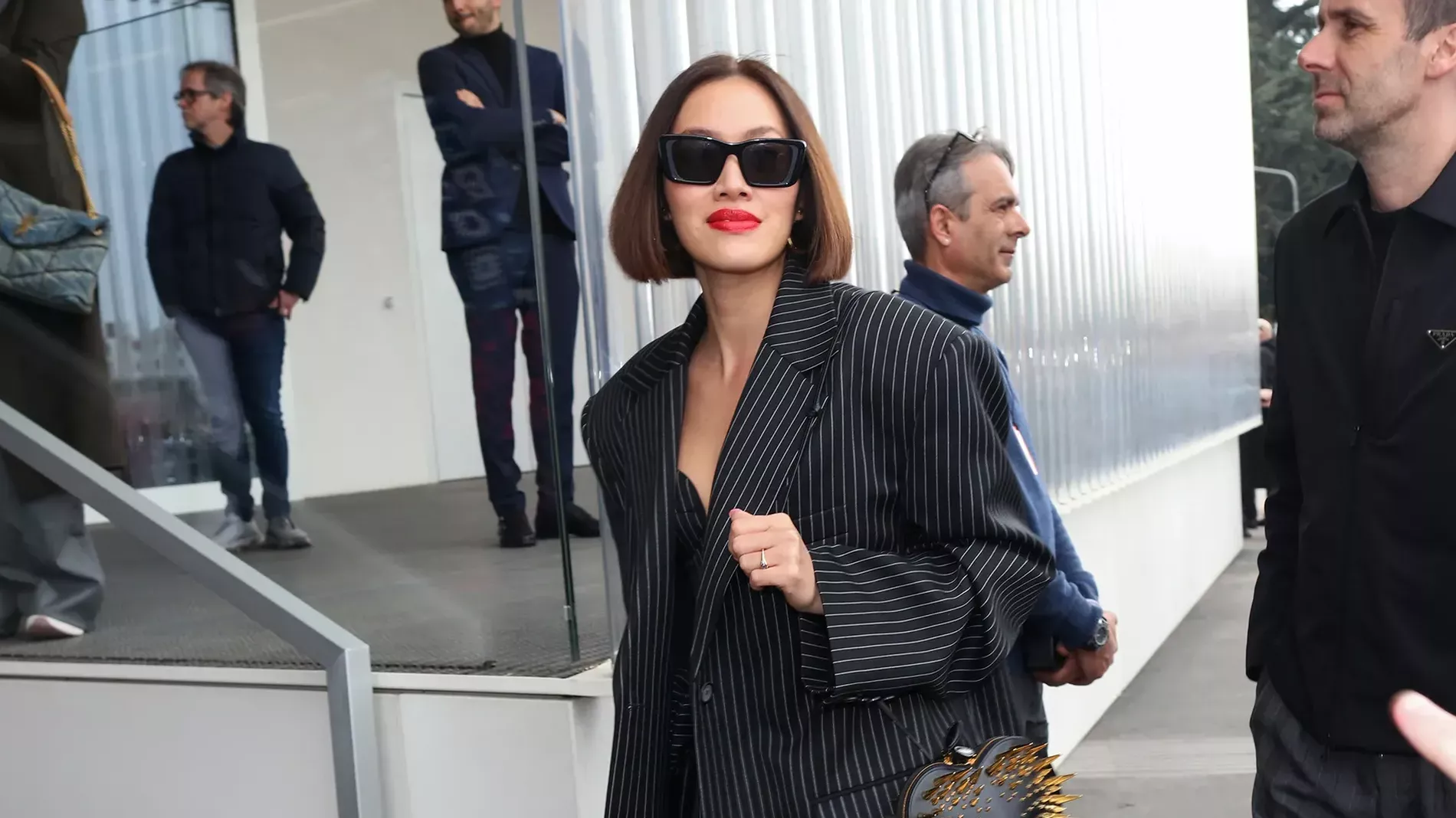 Milan Fashion Week guest wears pinstripe blazer with matching dress and sheer stockings