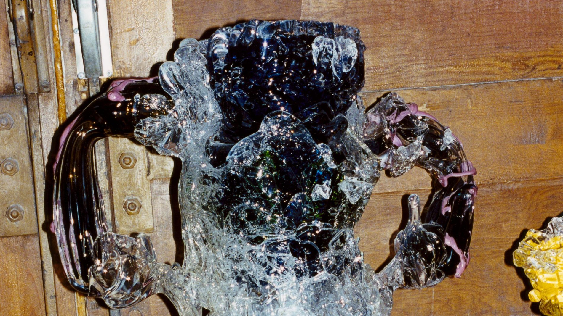 Highley detailed glass sculptured standing on a grafitti podiumwith a wooden background 