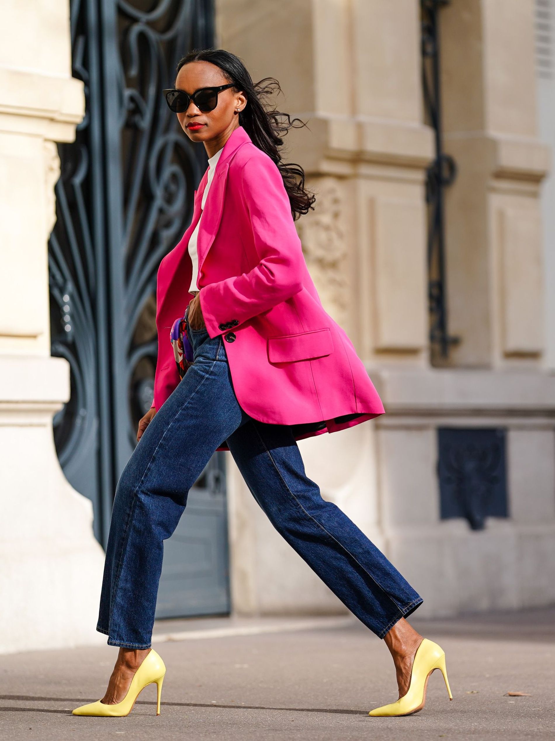 Woman wearing bright pink suit jacket, a trend to shop for spring/summer 2022