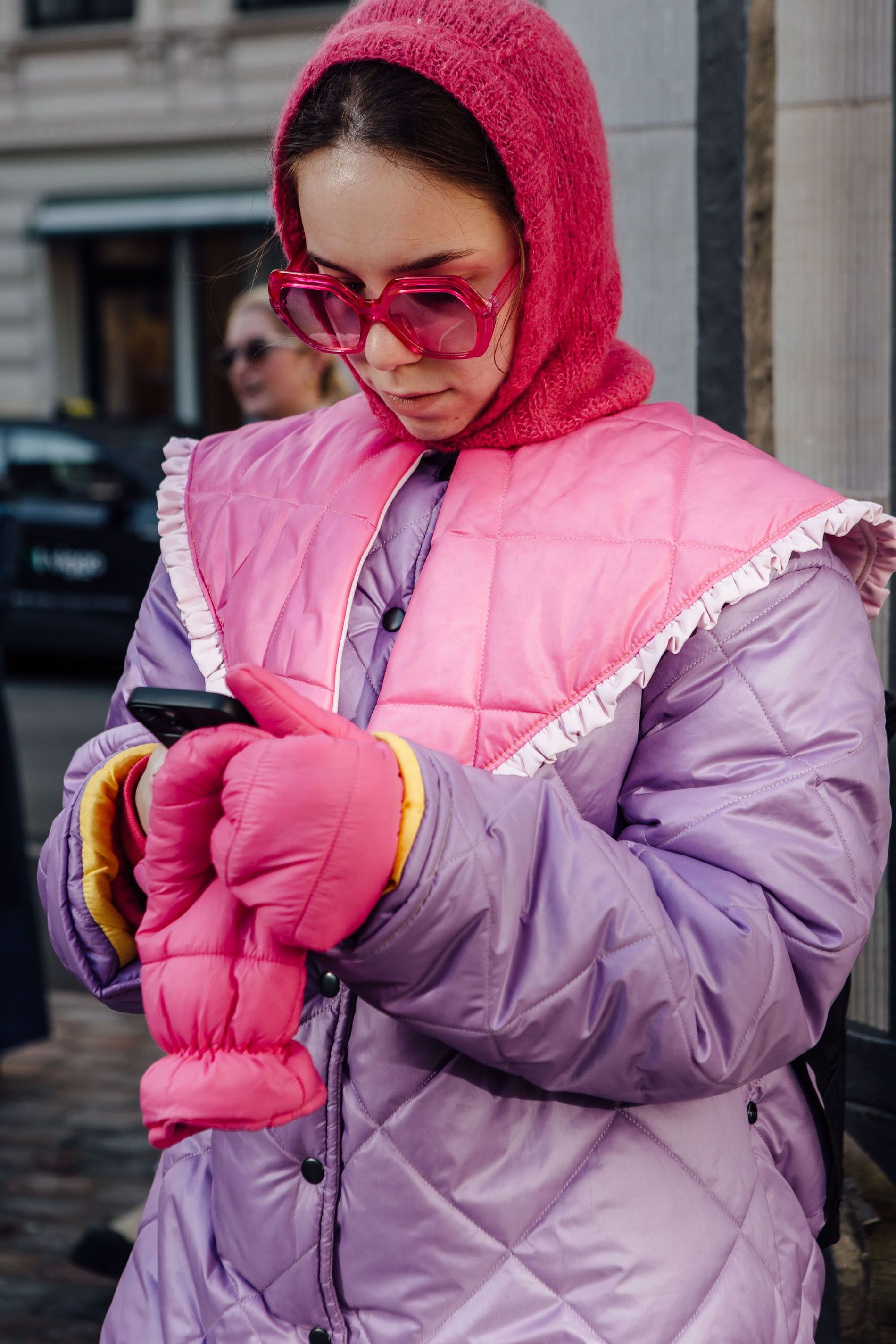 A Copenhagen Fashion Week AW23 guest wears a hot pink balaclava with matching sunglasses and gloves