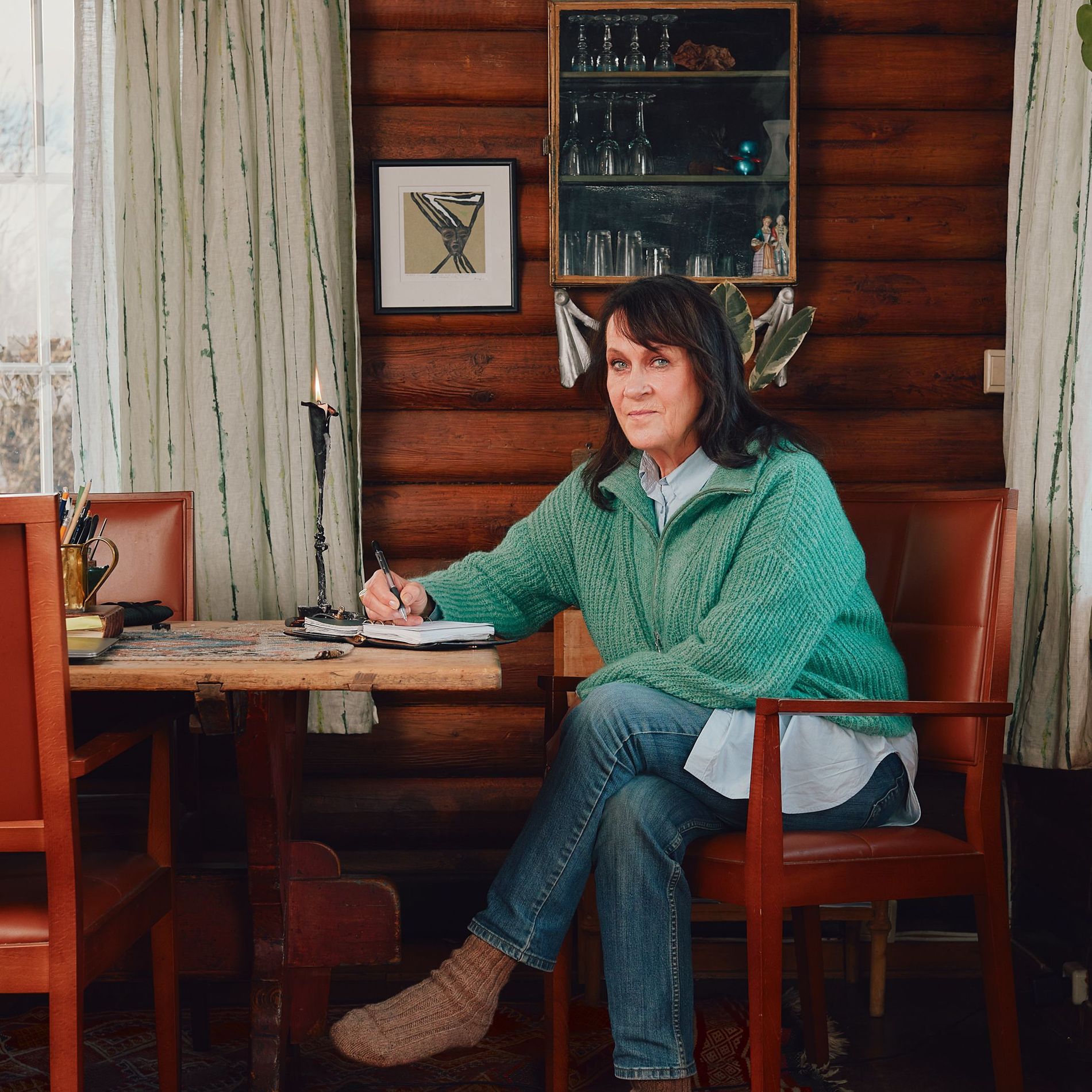 A woman sitting at a table, writing