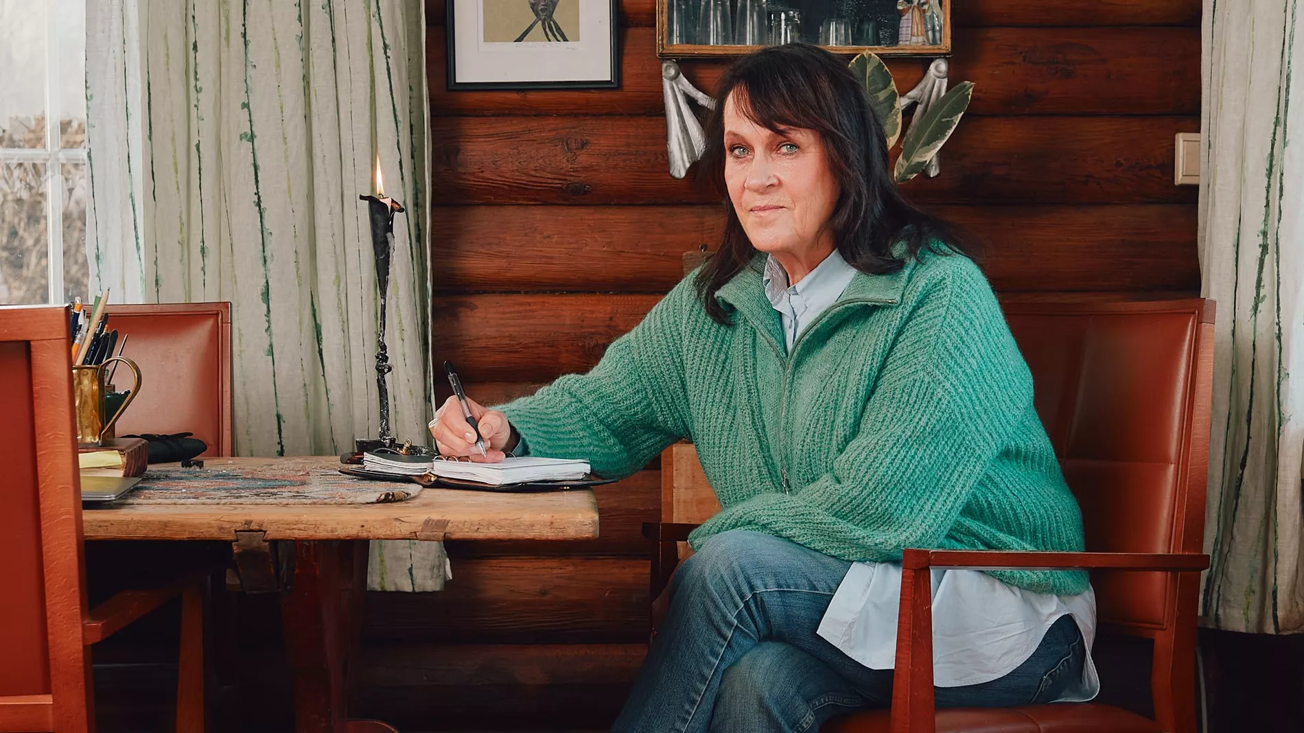 A woman sitting at a table, writing