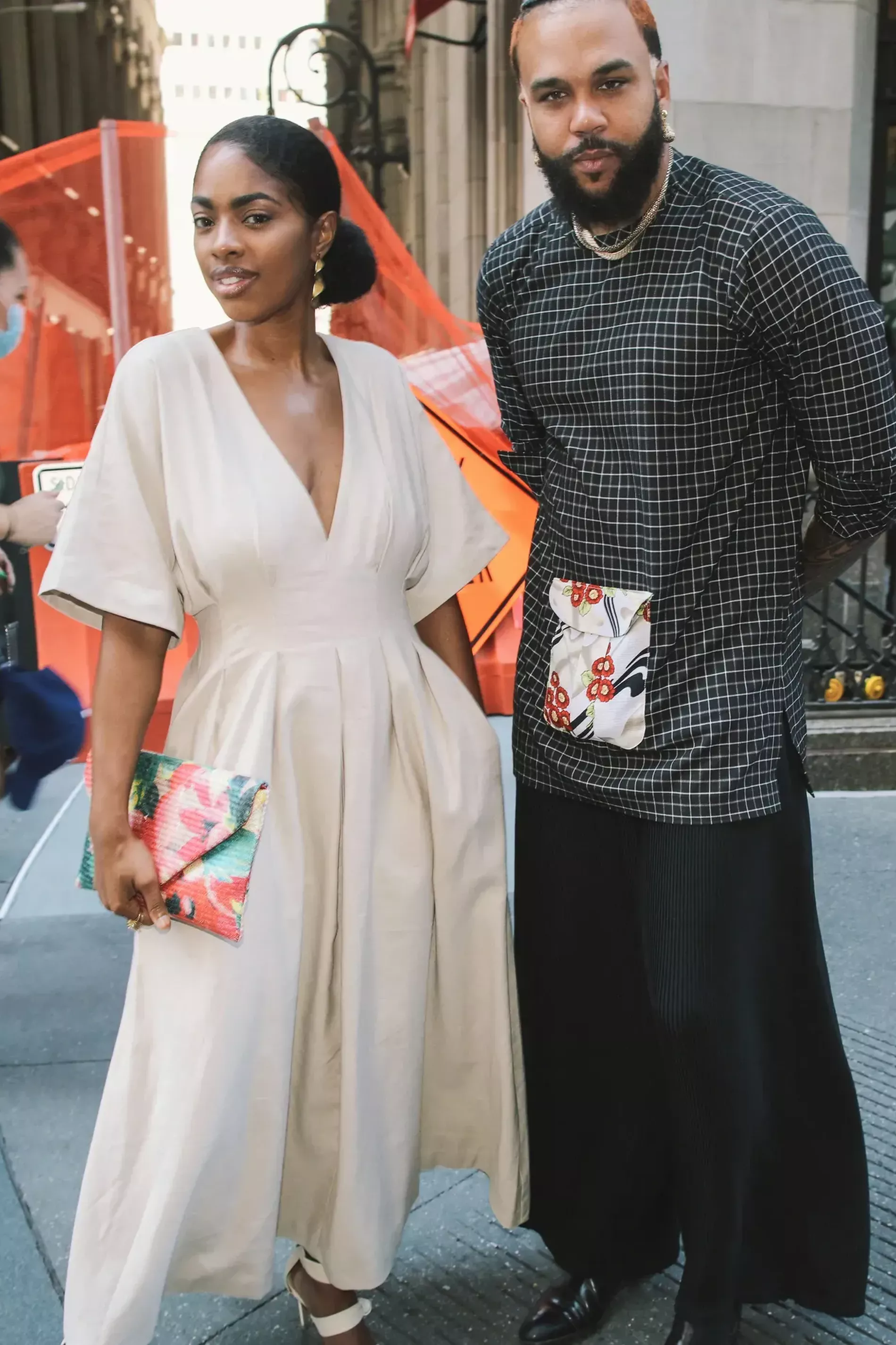 New york fashion week guest wears cream dress and floral clutch