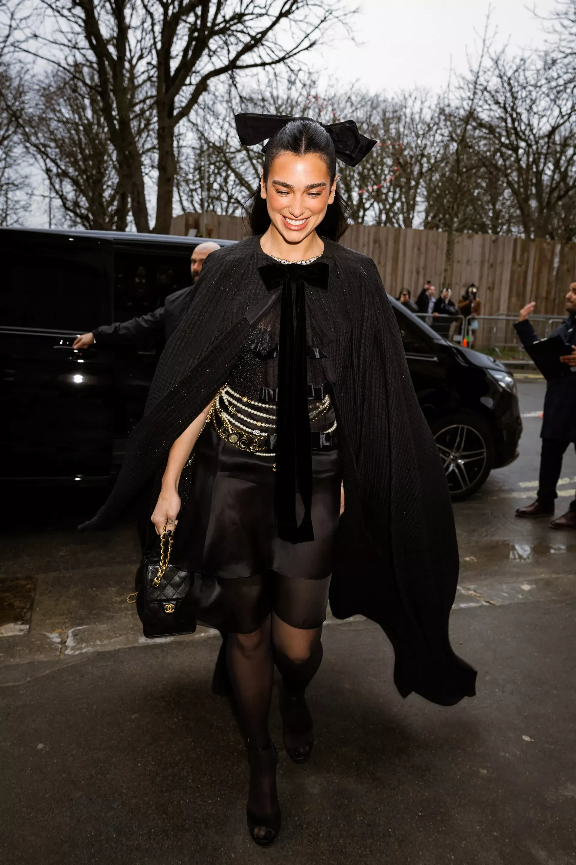 Dua Lipa attending the Chanel Haute Couture show for SS25 wearing a full Chanel look with stacked pearl belts 