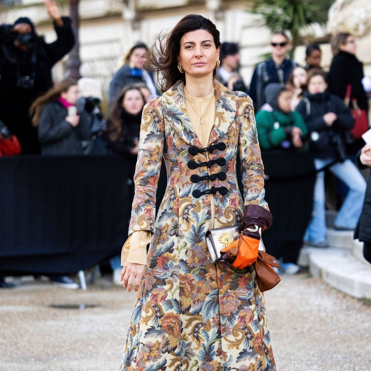 Giovanna Engelbert on the streets of Paris wearing patterned coat, black leather boots and Schiaparelli bag 