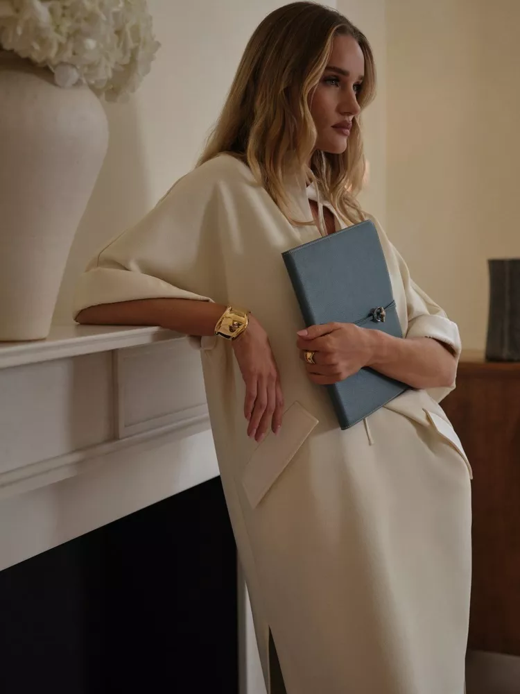 Rosie Huntington-Whiteley wears cream dress in monochromatic room holding pale blue notebook