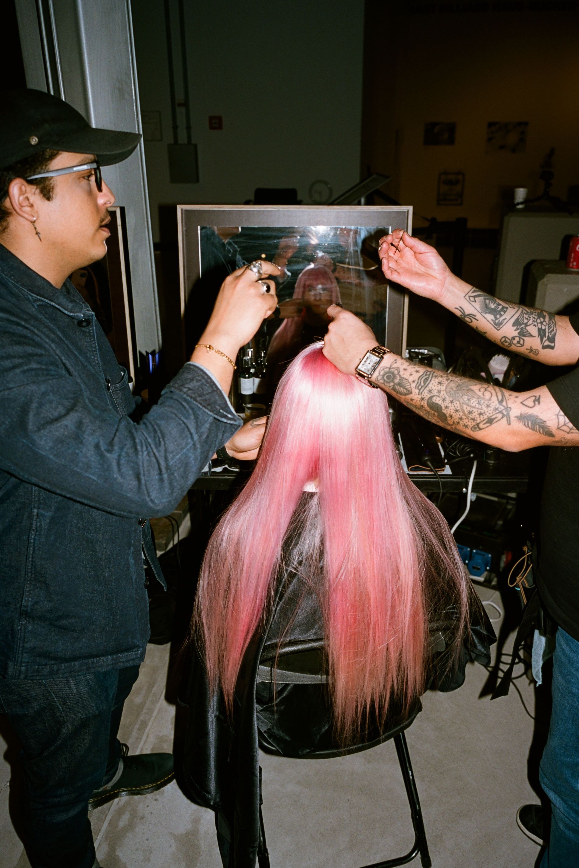 Model wearing a long pink wig gets her hair adjusted ahead of Ganni's AW23 show