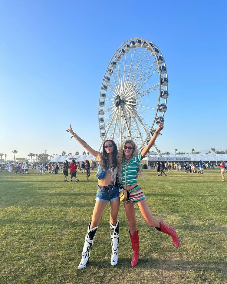 Emili Sindlev and Kylie Verzosa pose in cowboy inspired looks infront of the Coachella Ferris wheel
