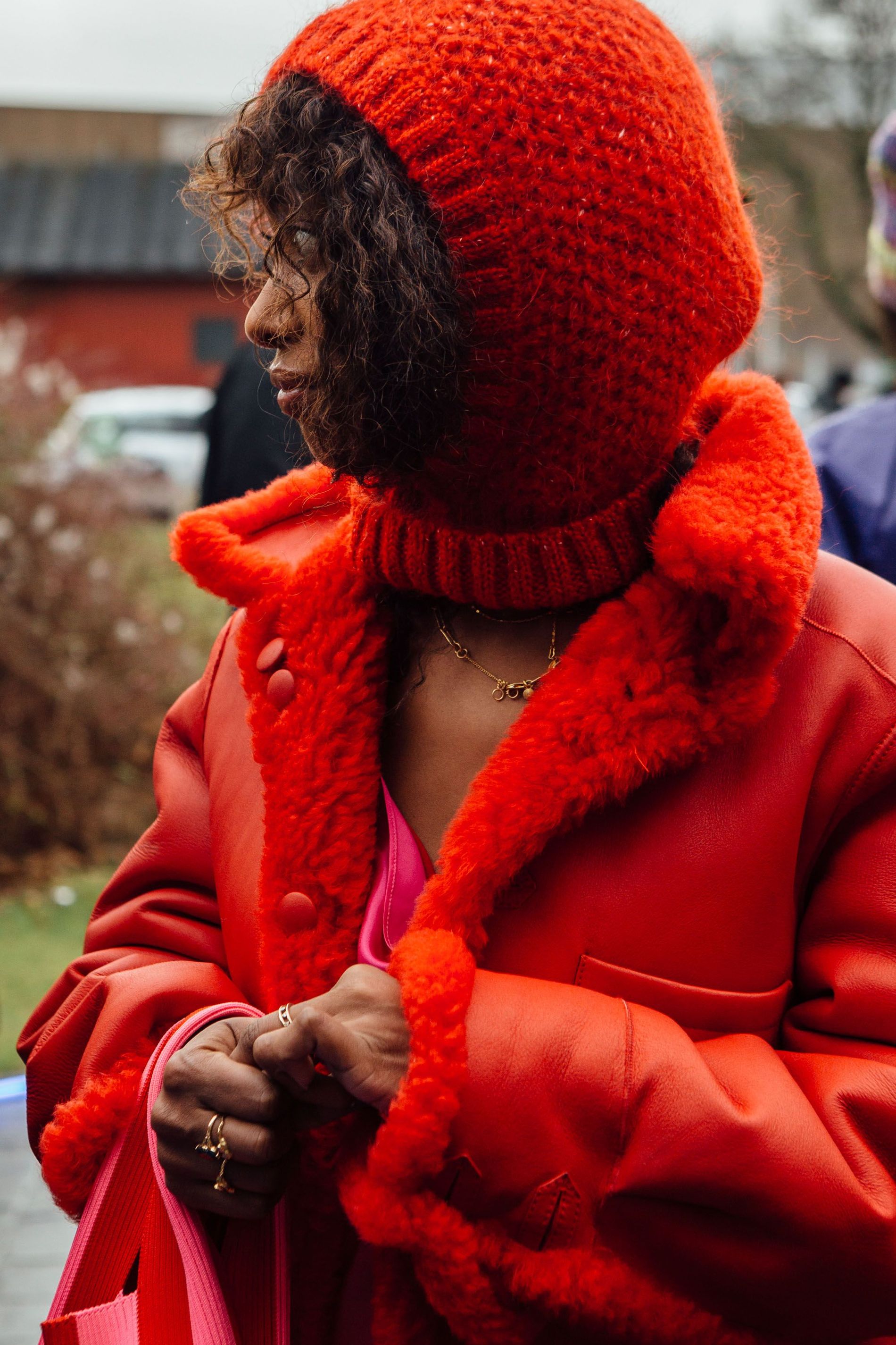 A guest wears a bright red balaclava with a matching shearling jacket