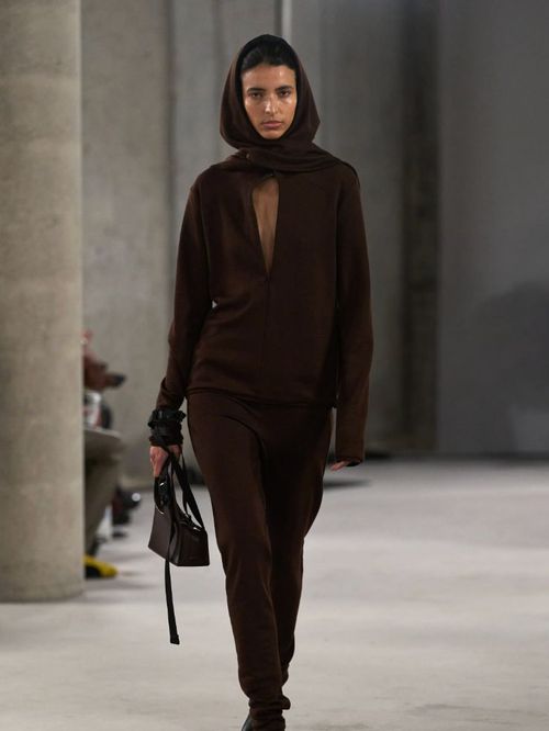Model walks Johanna Parv's runway Fall 2026 show wearing chocolate brown hood, cardigan and sweatpants