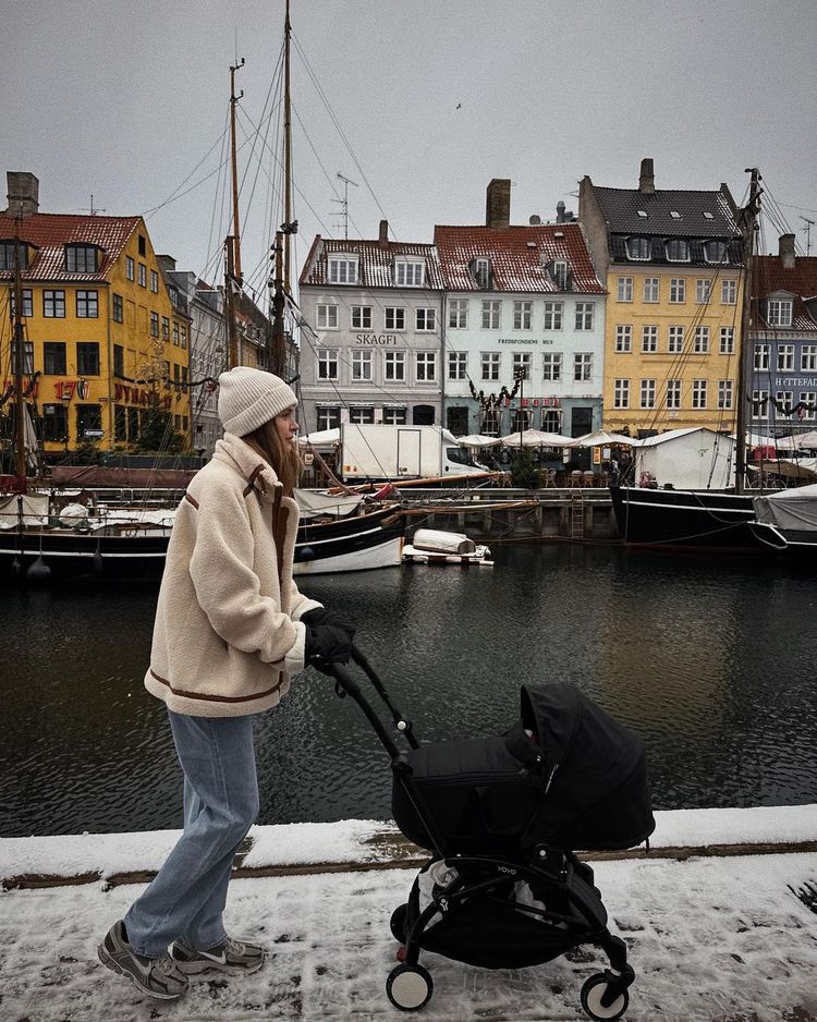 Supermodel Josephine Skriver in her Munthe shearling jacket, pushing a stroller through Copenhagen