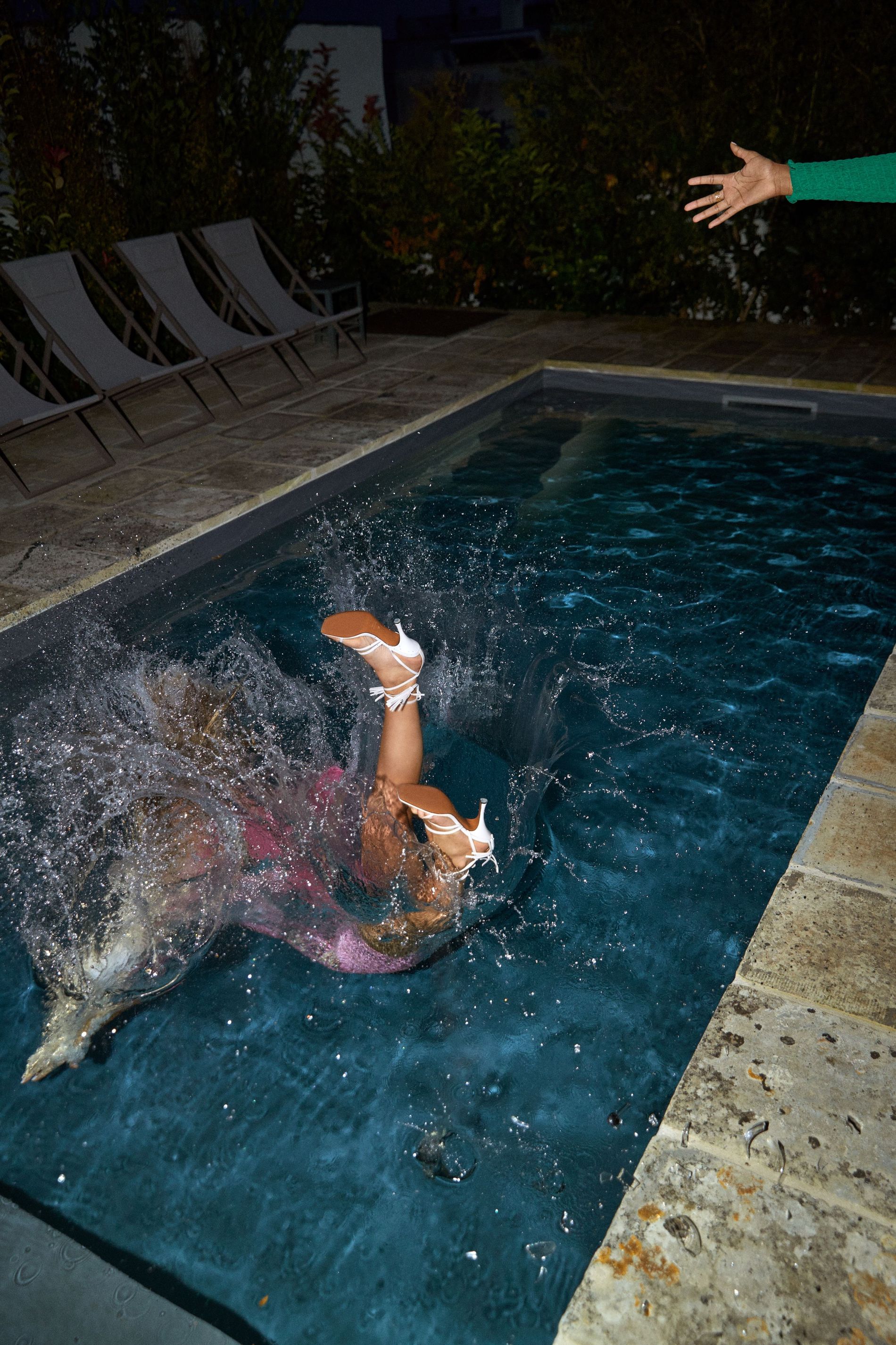 A model falls into the pool wearing ATP Atelier heels