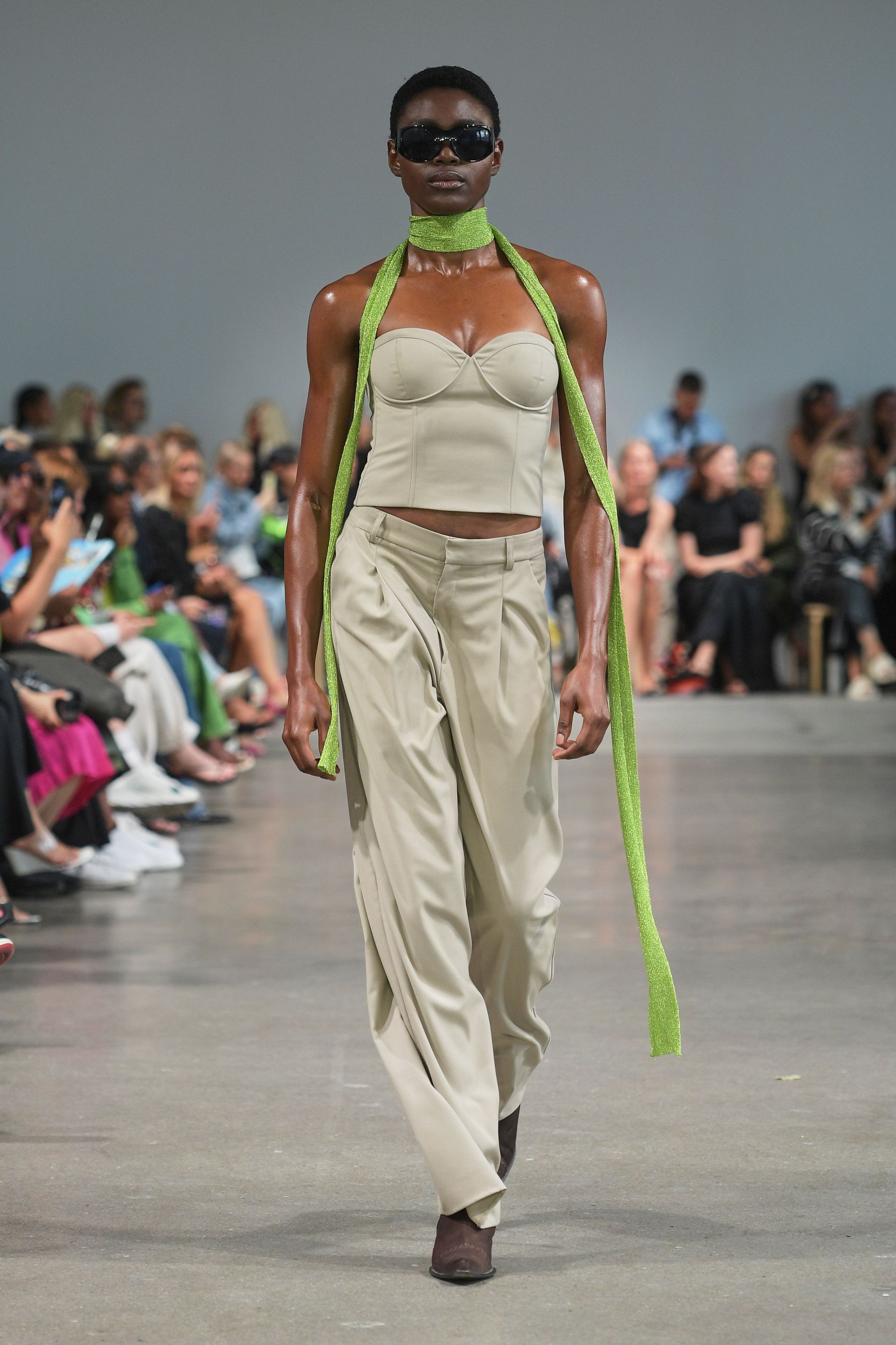 Model wears green skinny scarf on the SS23 runway of Gestuz