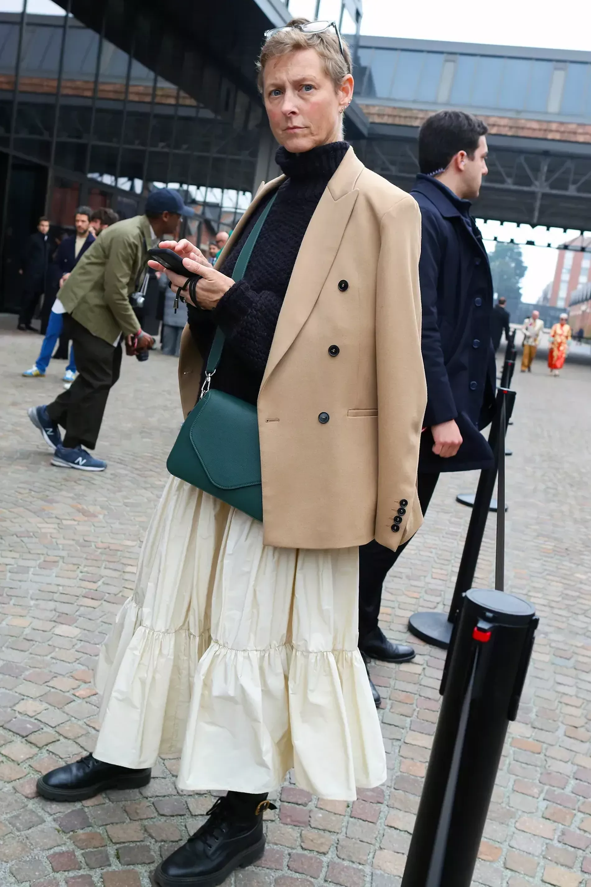 Milan Fashion Week guest wears beige blazer over black turtle neck and cream skirt 