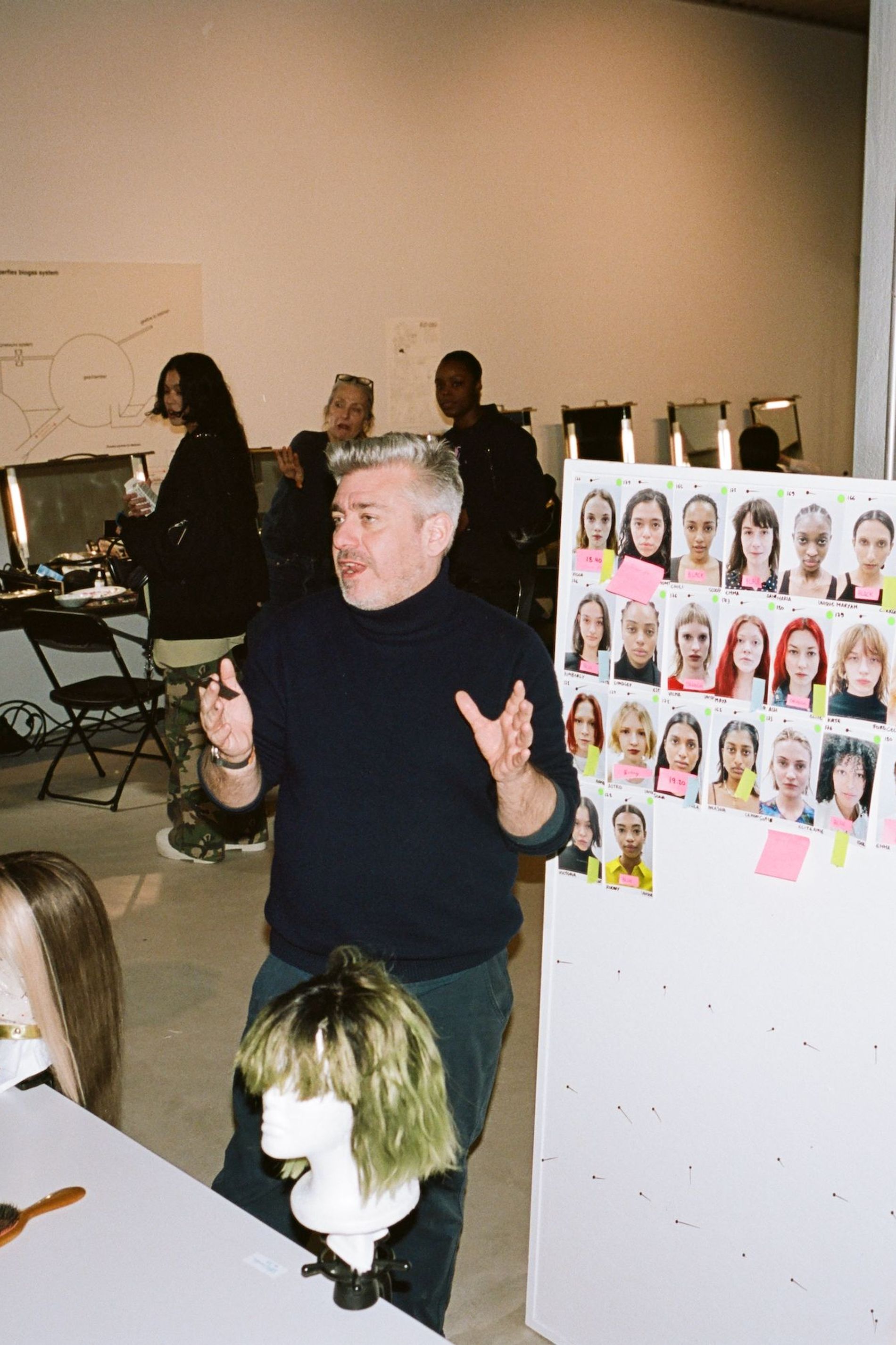 Cim Mahony briefs the team ahead of the show on the makeup looks in front of a look board