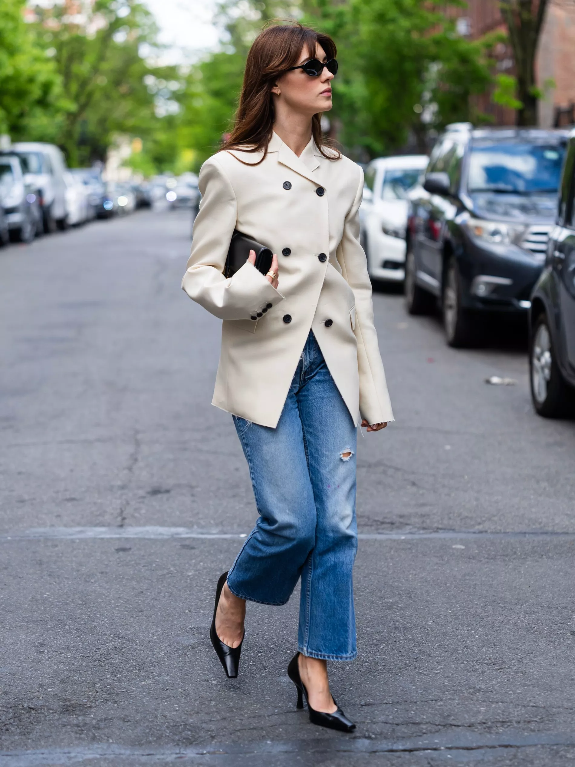 Daisy Edgar-Jones walks in New York wearing light wash jeans, Khaite beige jacket, Hagelstam Quartz pumps and Chimi Eclipse sunglasses