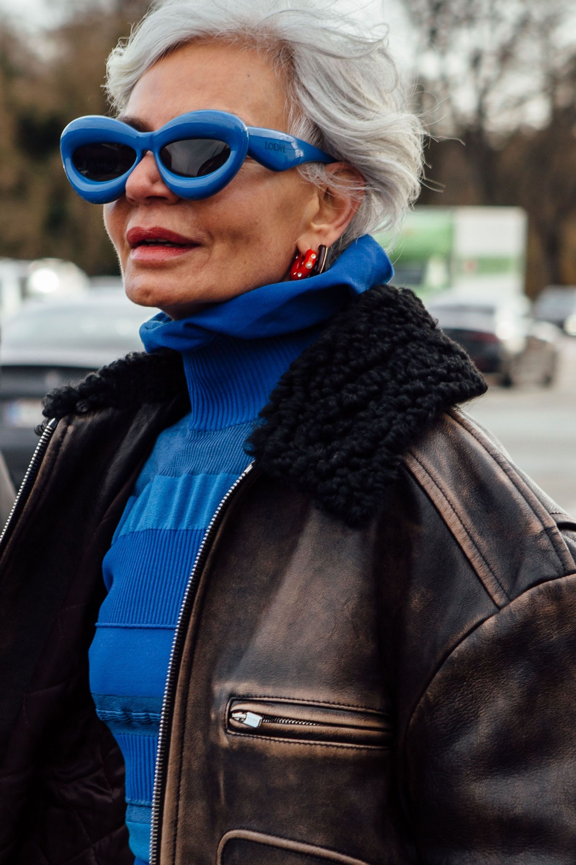 Guest wears blur Loewe bubble sunglasses with matching knitted top and an aviator jacket