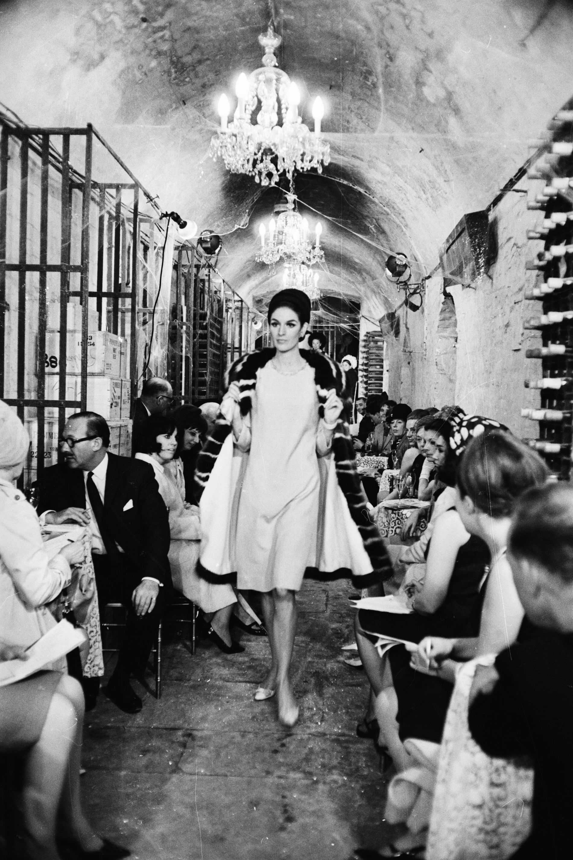 A model walks for Balmain's 1965 show, hosted in a wine cellar