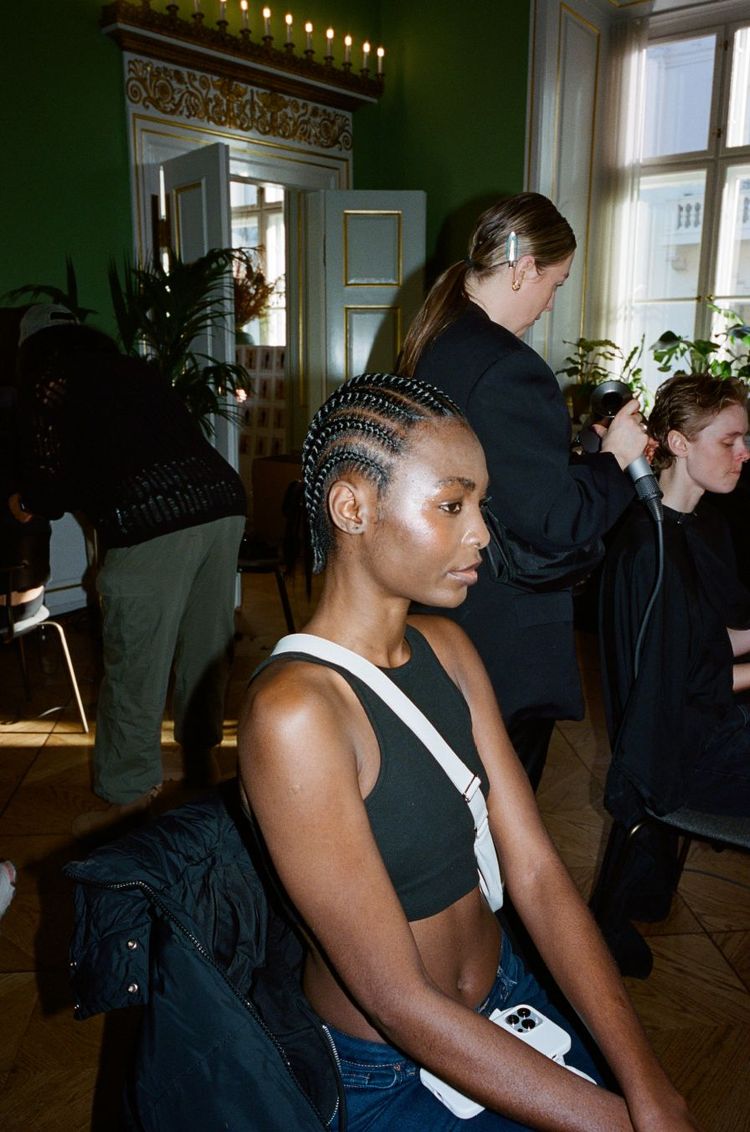 A model with cornrows backstage at The Garment's AW24 runway show at Copenhagen Fashion Week 