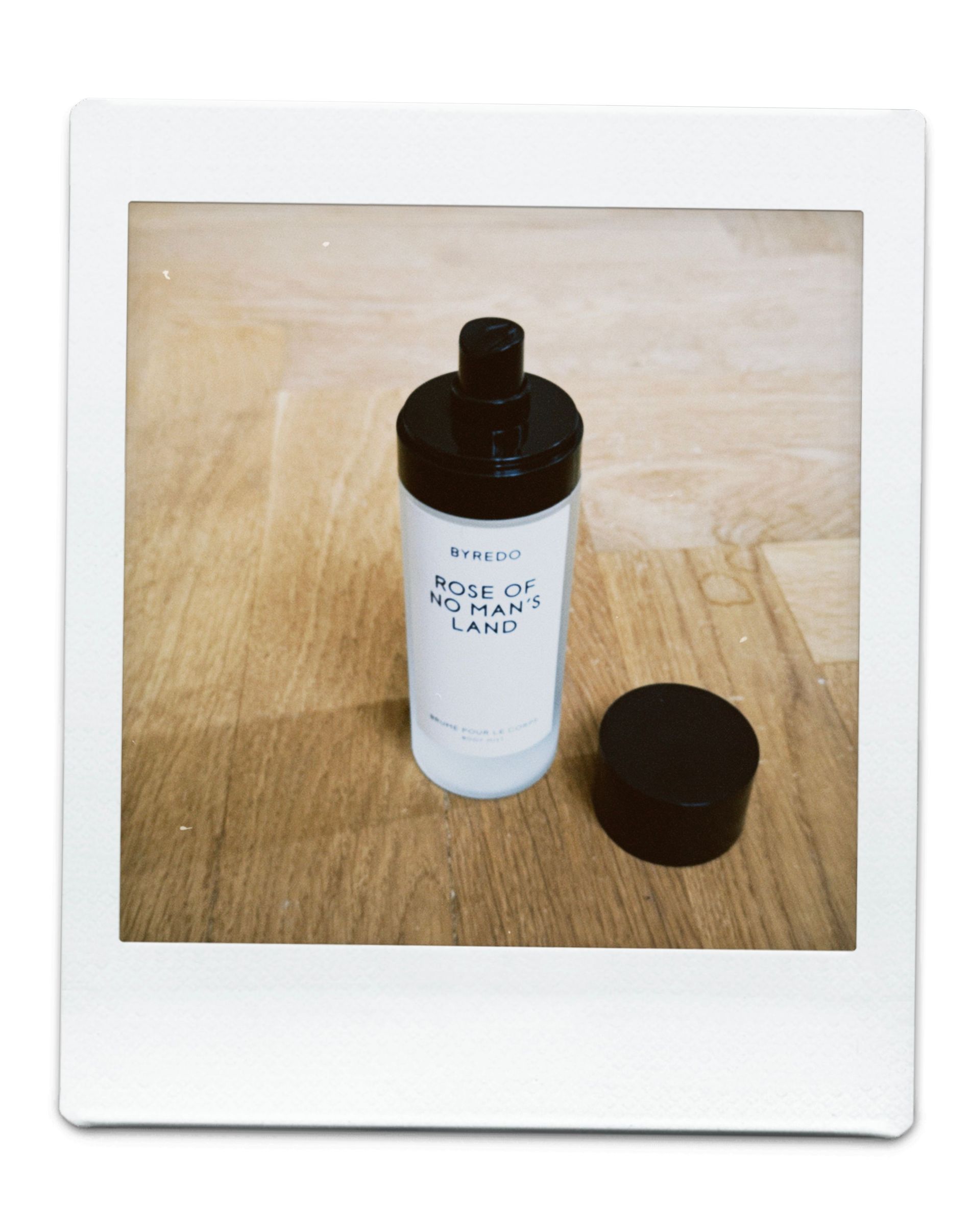 Body mist in a transparent bottle with black top