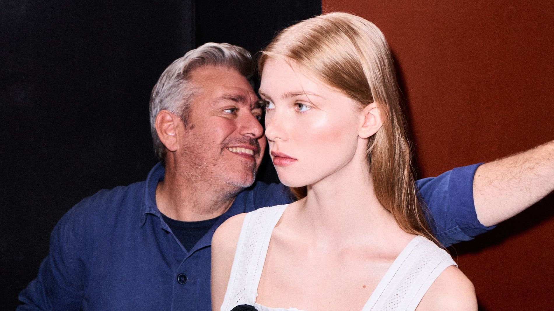 Hair stylist Cim Mahony is adjusting a model's hair before the runway