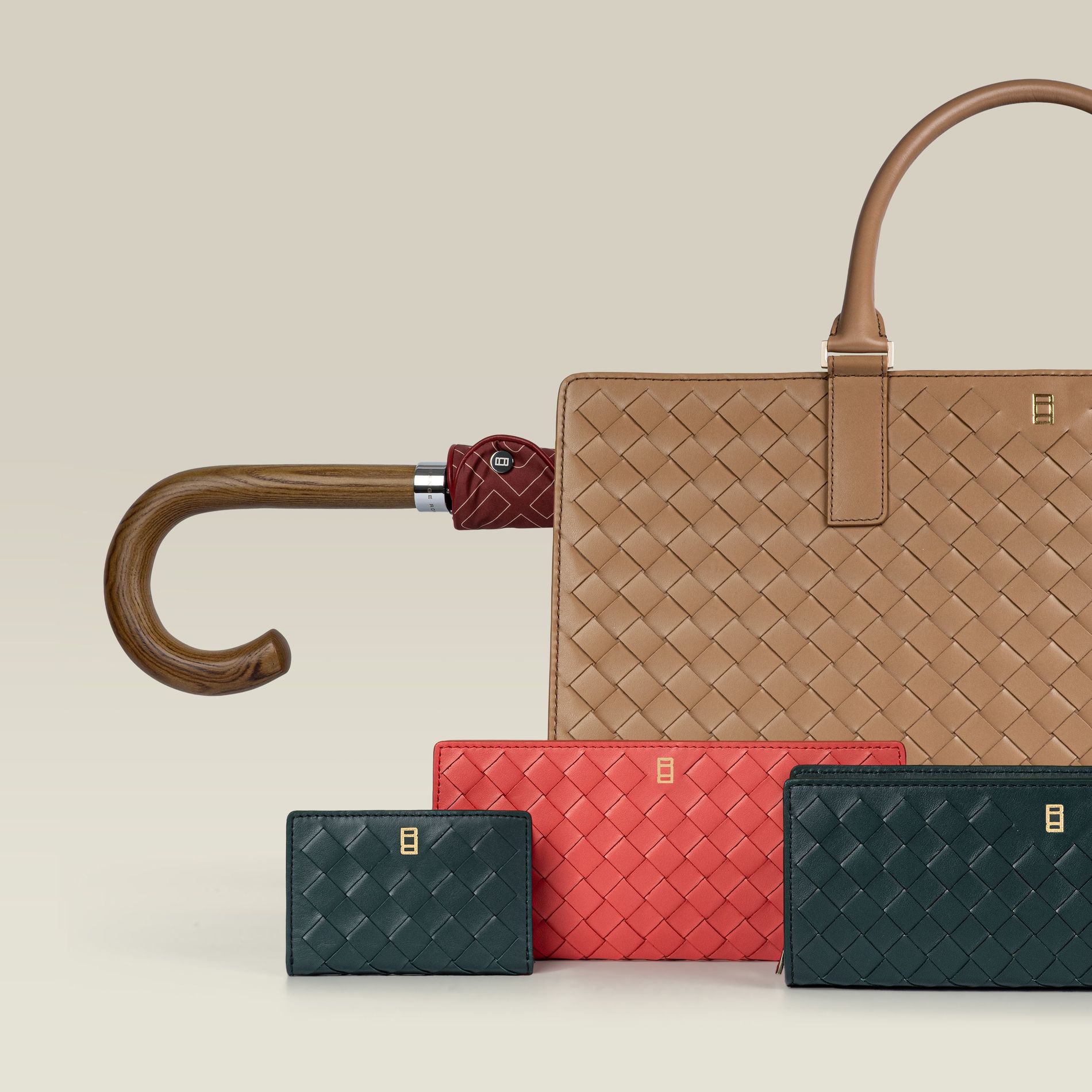 Range Rover British Summertime Collection woven leather goods in tan, coral, and heritage green, with a crook-handled Fulton umbrella