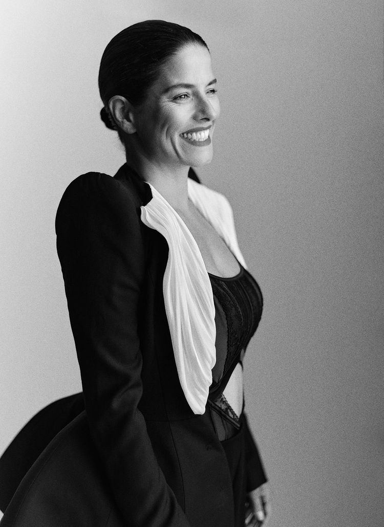 Photo from Hunkemöller photoshoot for Vogue issue 32, a black and white picture with a lady smiling wearing a black satin dress with white details
