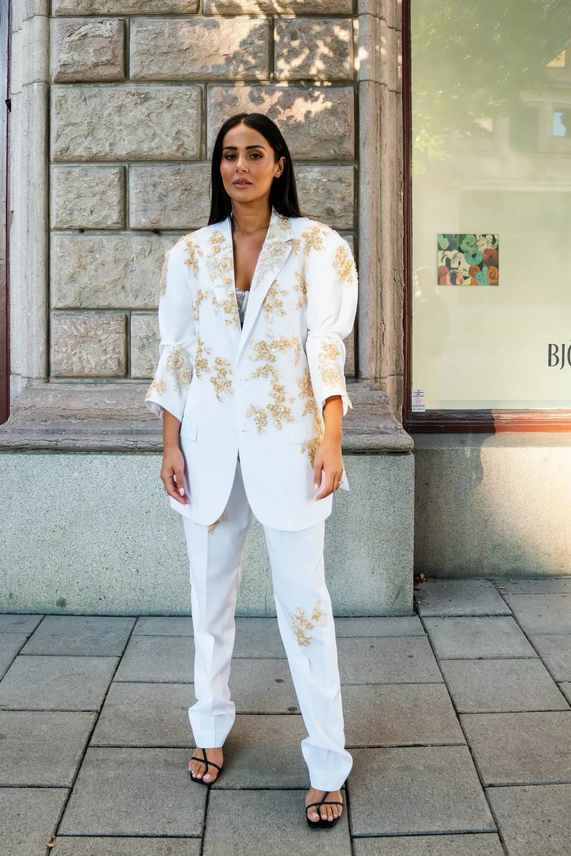 Stockholm fashion week guest wears white suit with golden elements