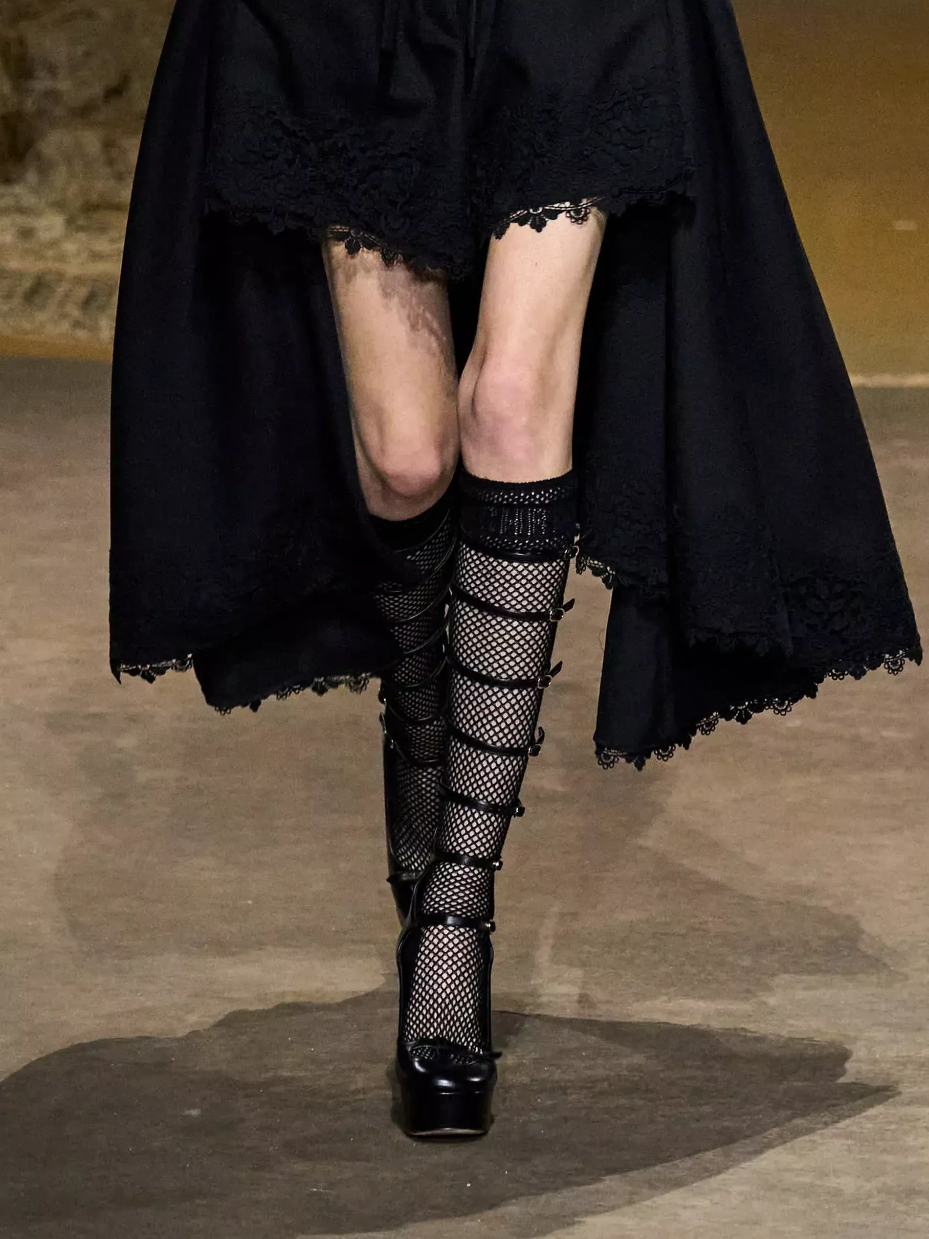 Model wears knee high fishnet socks on the SS23 runway of Dior