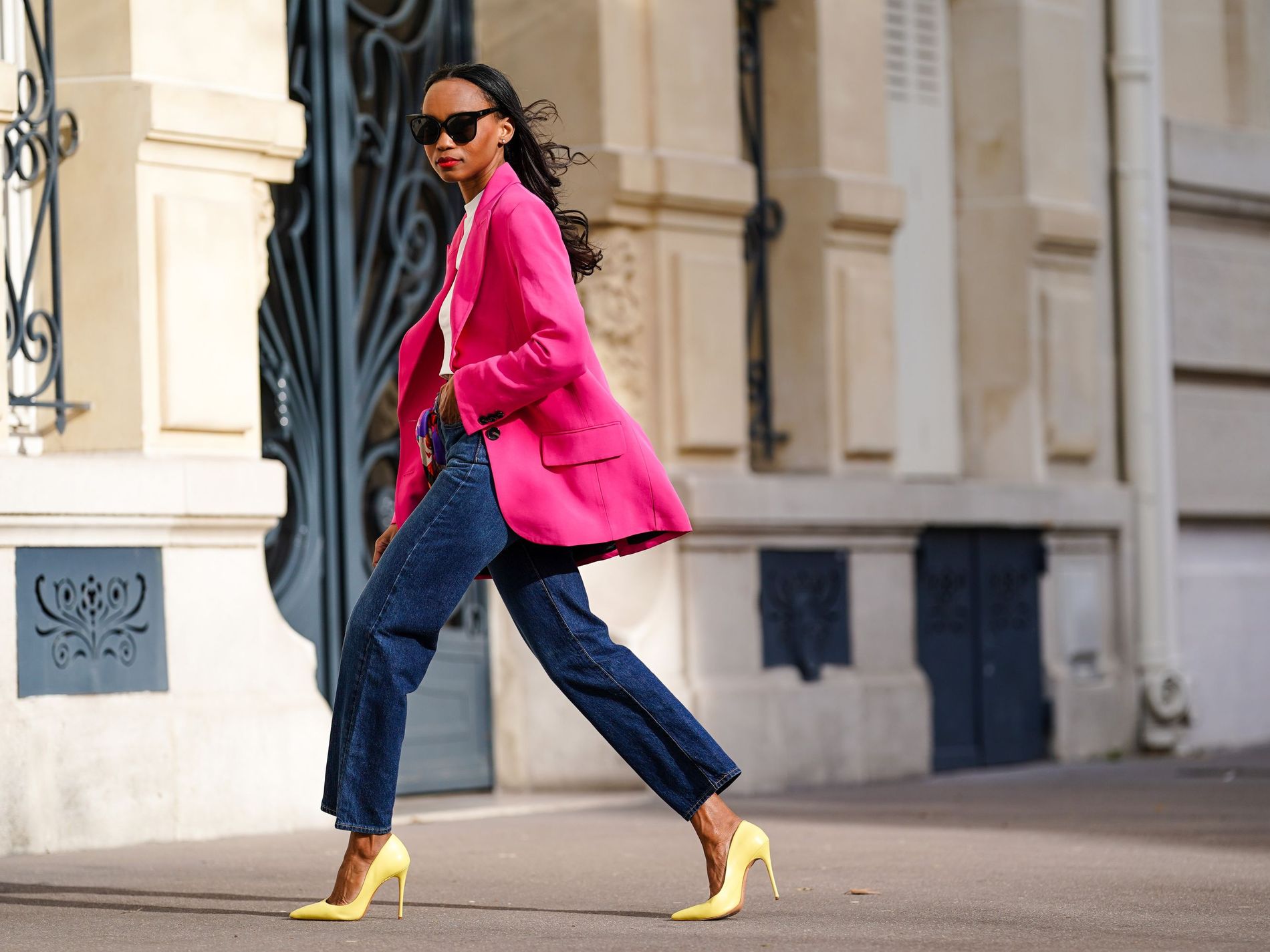 Woman wearing bright pink suit jacket, a trend to shop for spring/summer 2022
