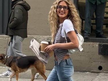Emili Sindlev looks the spitting image of Carrie Bradshaw wearing denim capris, a baby-T layered under a vest and sky-high heels during NYFW street style