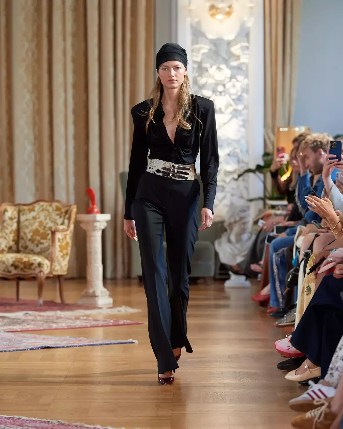 Runway look from Gestuz SS25 featuring a statement cow print belt cinched over black tailoring