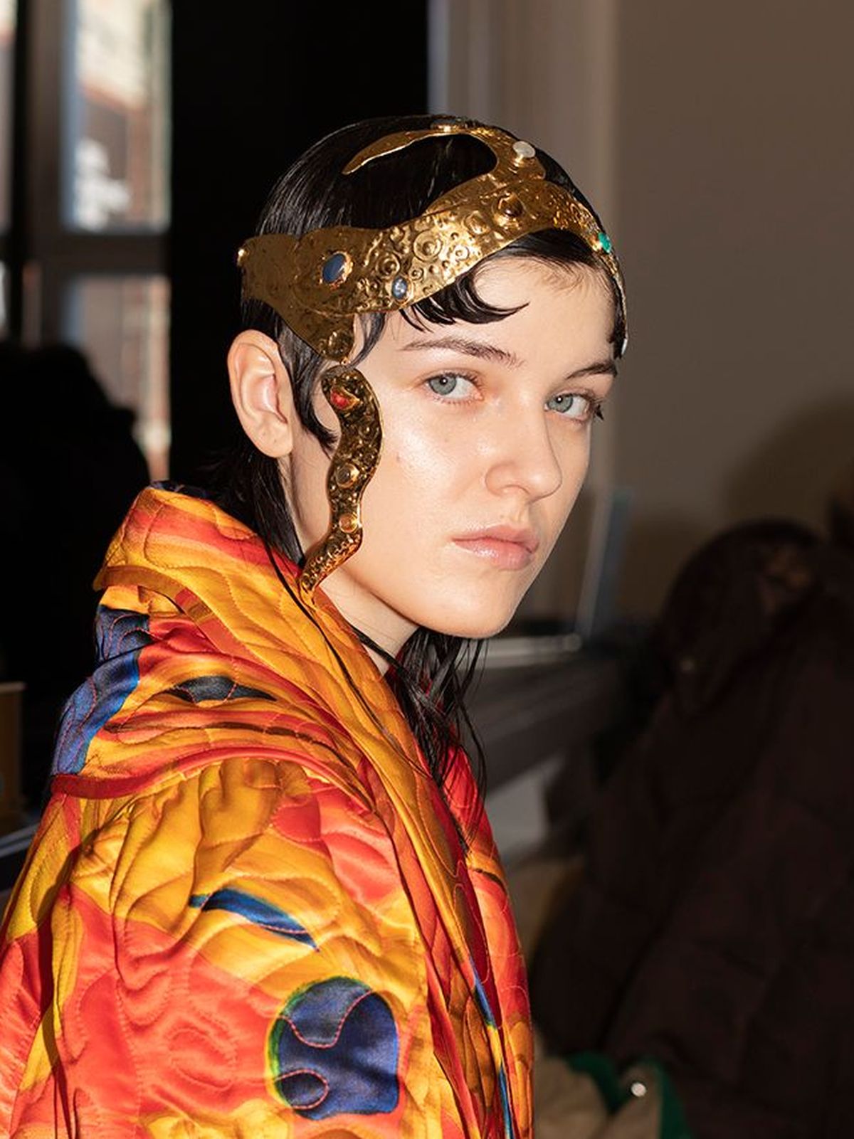 Model backstage at Helmstedt wears golden head piece