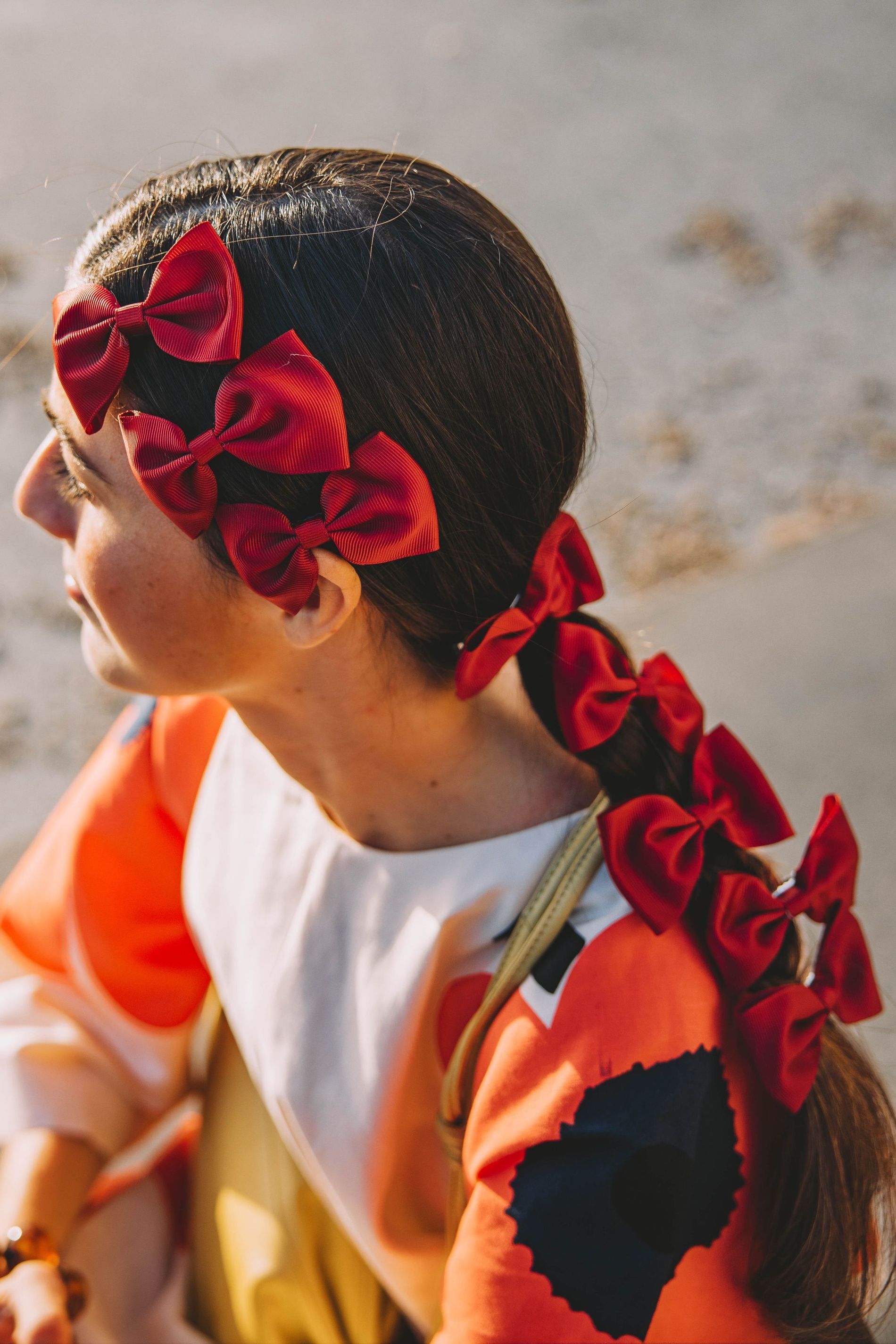 A guest at CPHFW poses for a street style photo wearing multiple bows in her hair