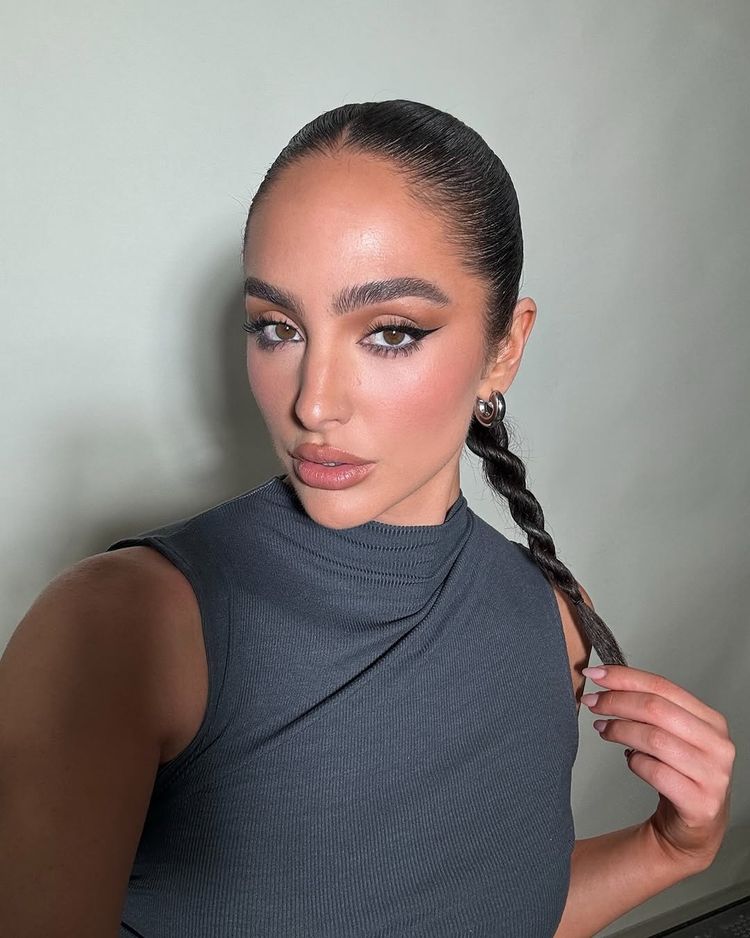 Kardashian makeup artist Ash K. Holm has her hair slicked back into a rope braid and wears an inspiring sharp eye liner