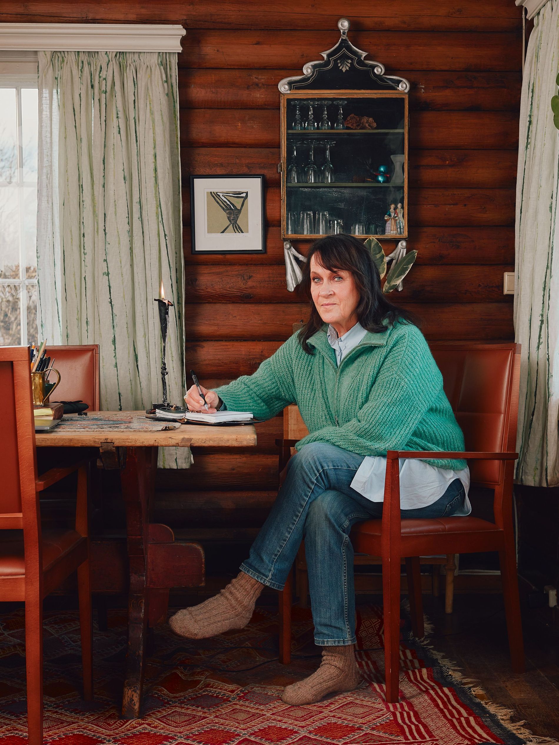 A woman sitting at a table, writing