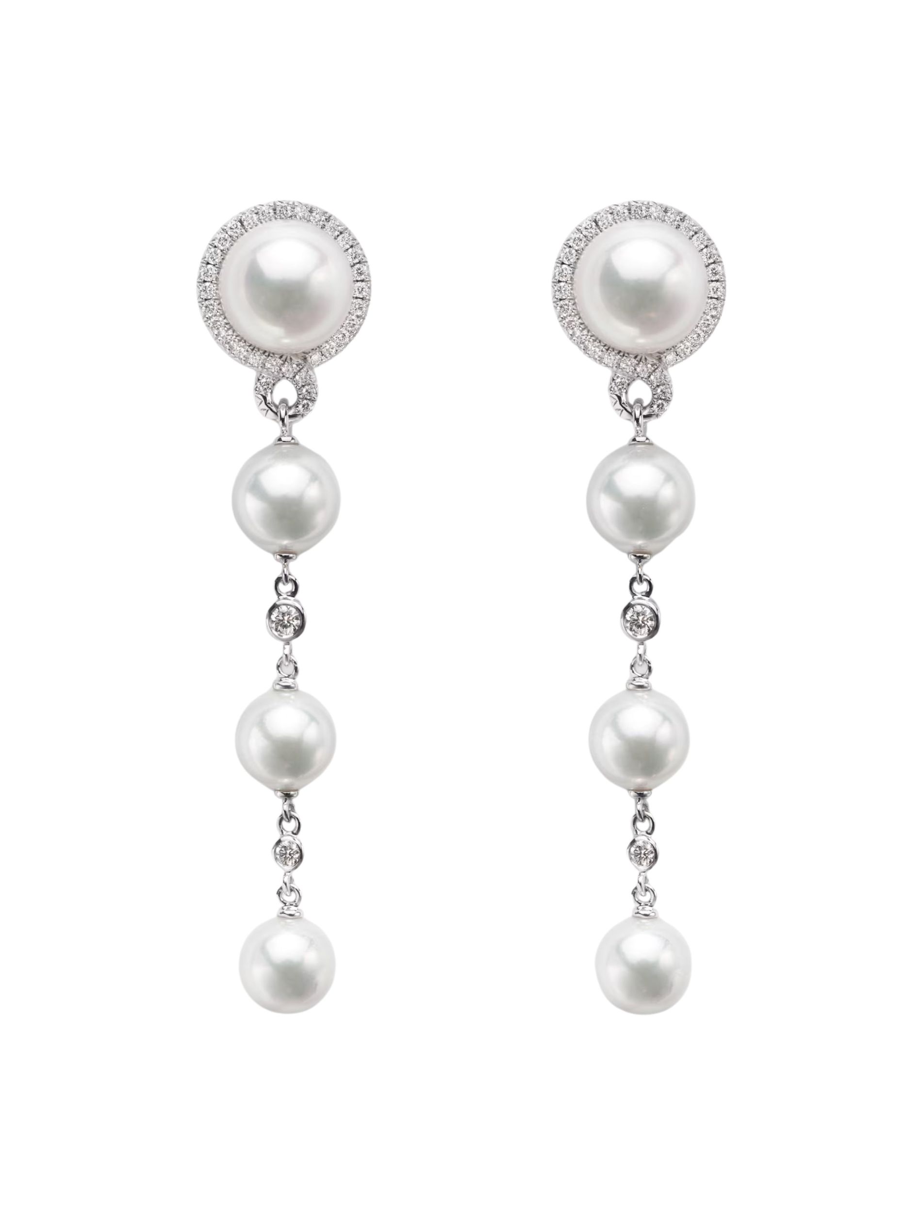 Pearl drop and diamond earrings set in silver from Mikimoto against a white background