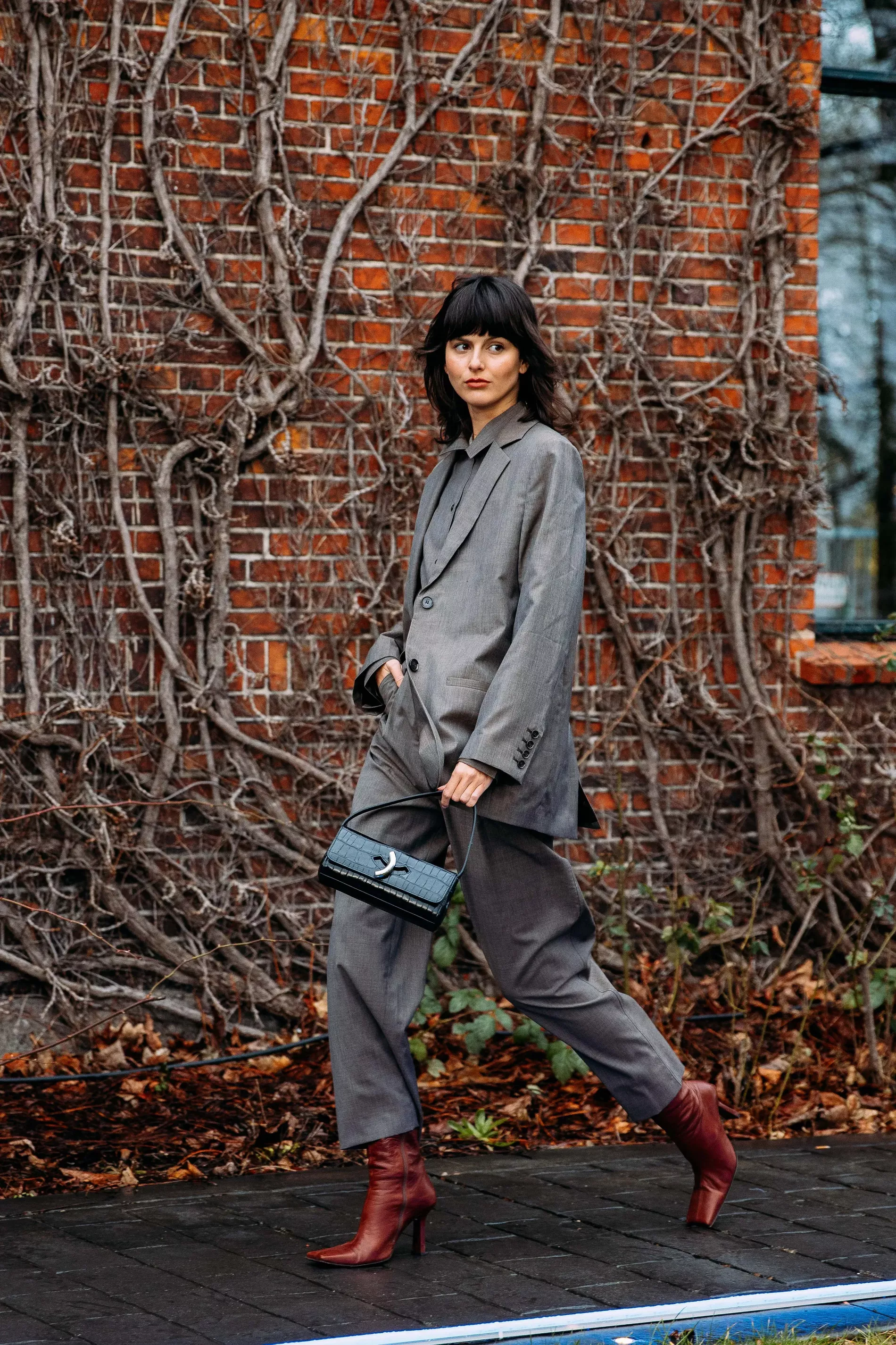 Copenhagen fashion week guest wears grey suit with leather heeled boots 