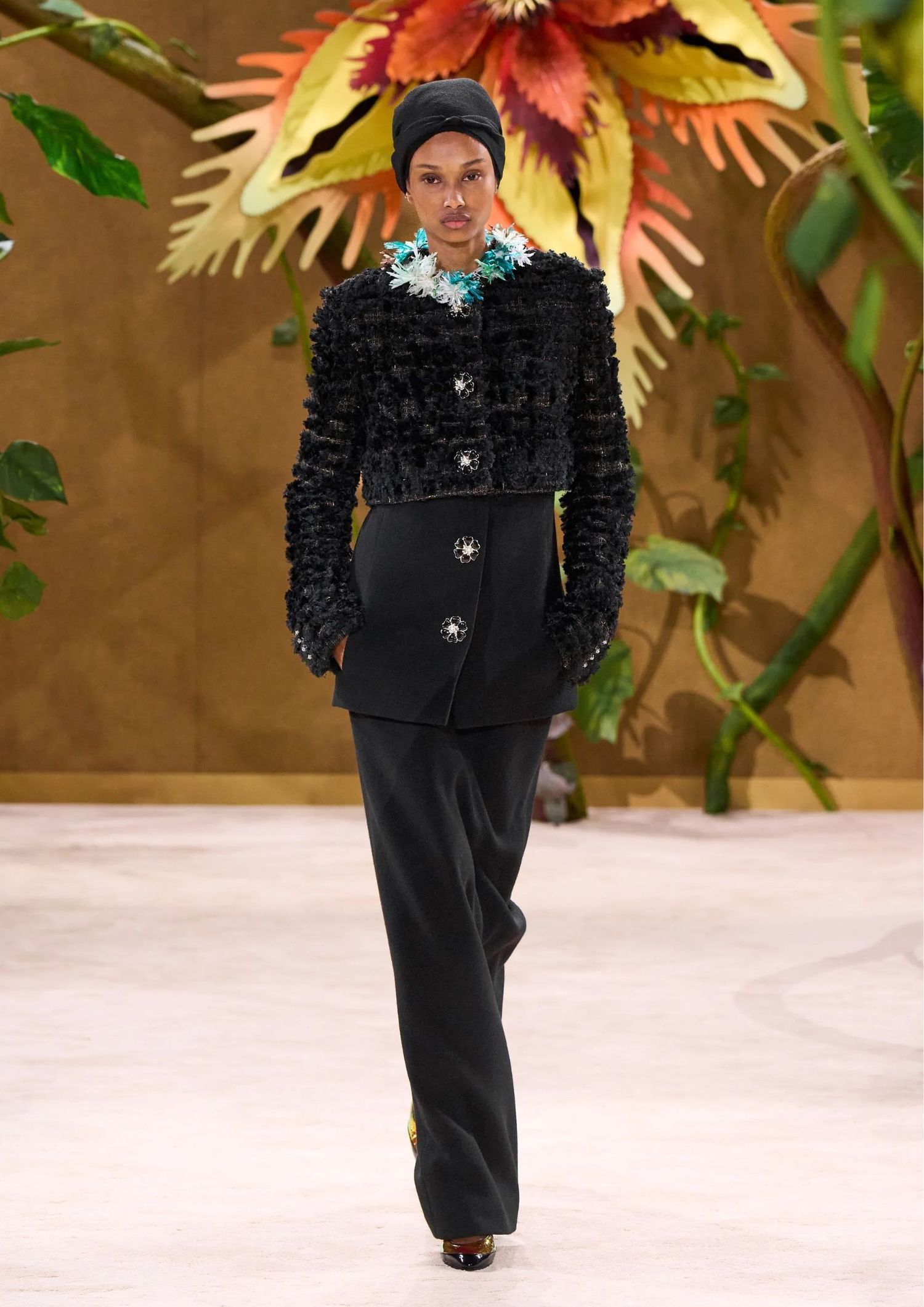 Crpped textured jacket, a longline buttoned top, wide-leg trousers, a black headscarf, and pointed-toe pumps