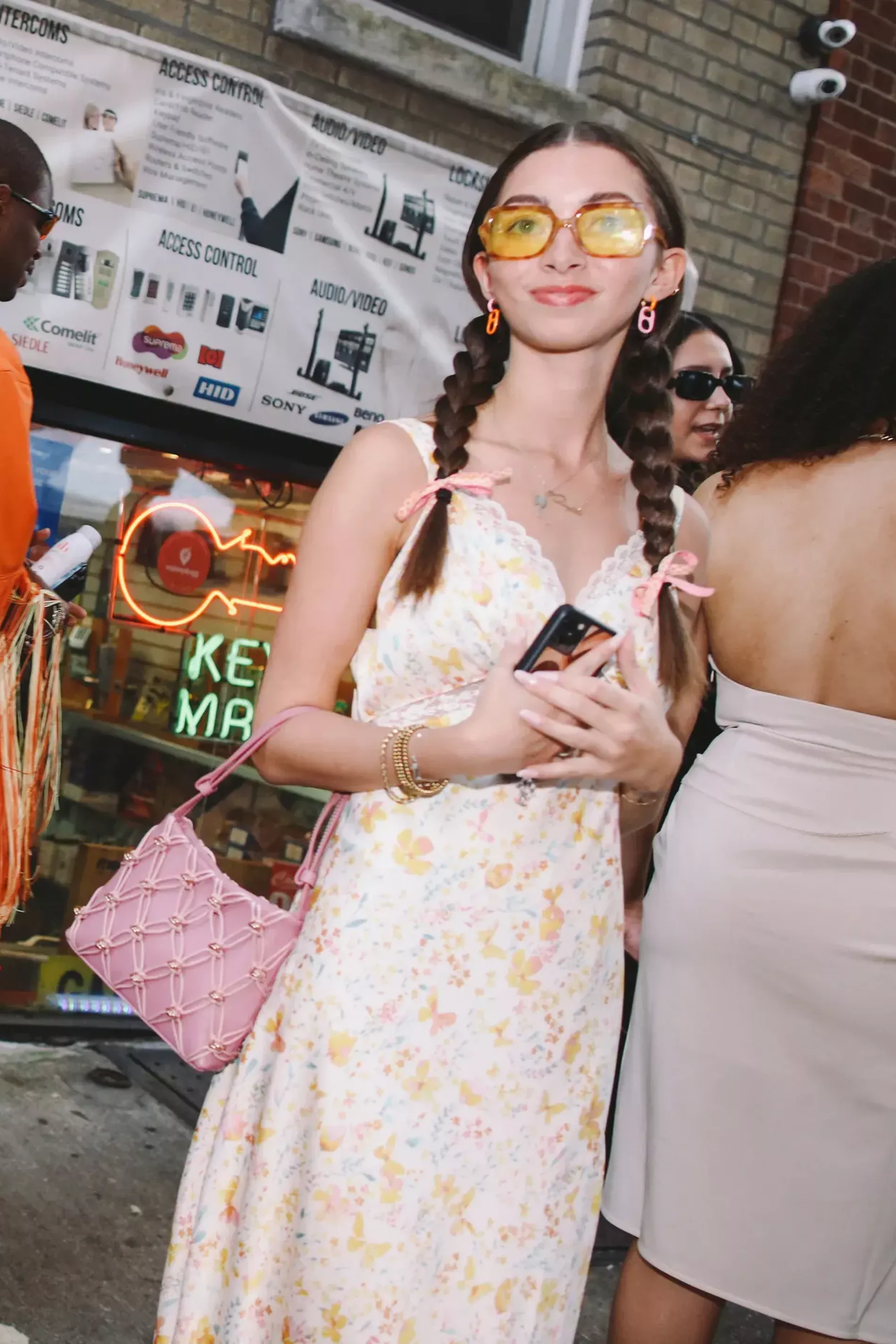 New York fashion week guest wears etheral flower dress with matching sunglasses and pink purse