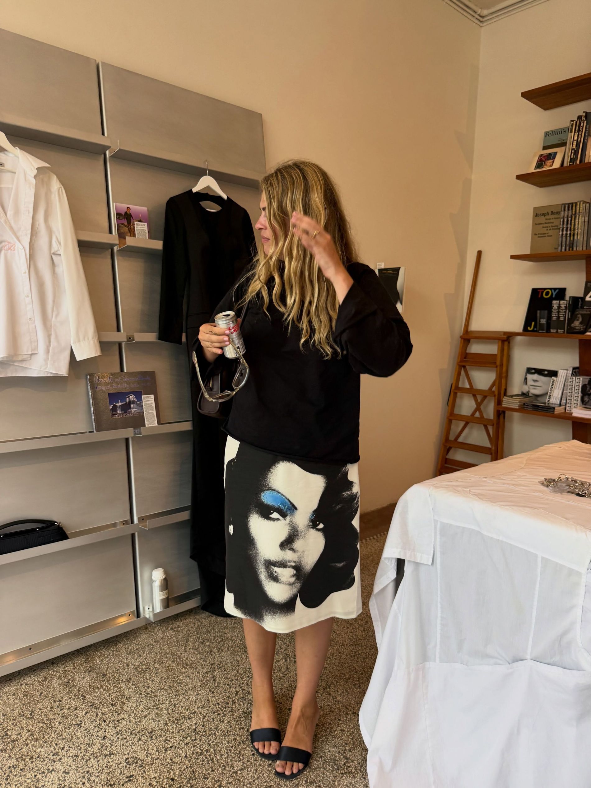 Sidsel Alling stands in a room wearing black jumper, black sandals and a Versace skirt