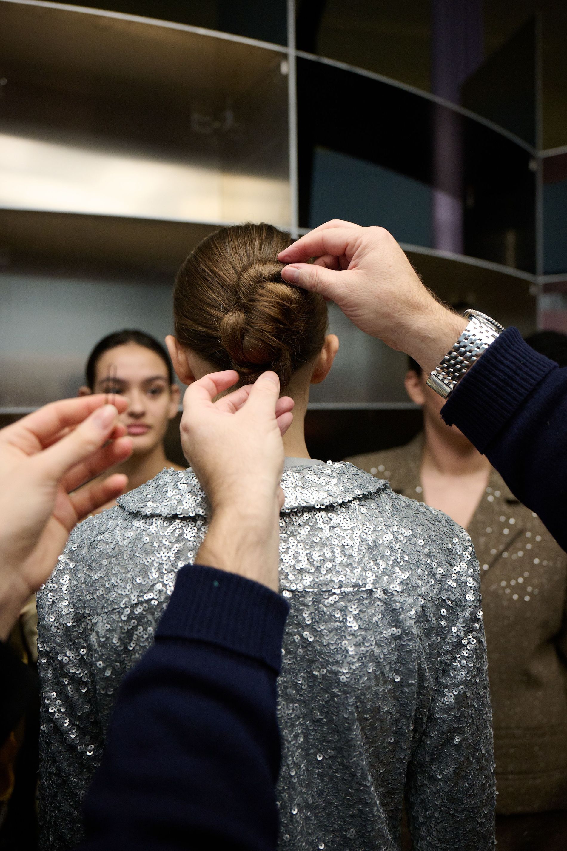 A model gets her hair pinned up in a bun backstage at Stine Goya's AW24 runway show Copenhagen Fashion Week 