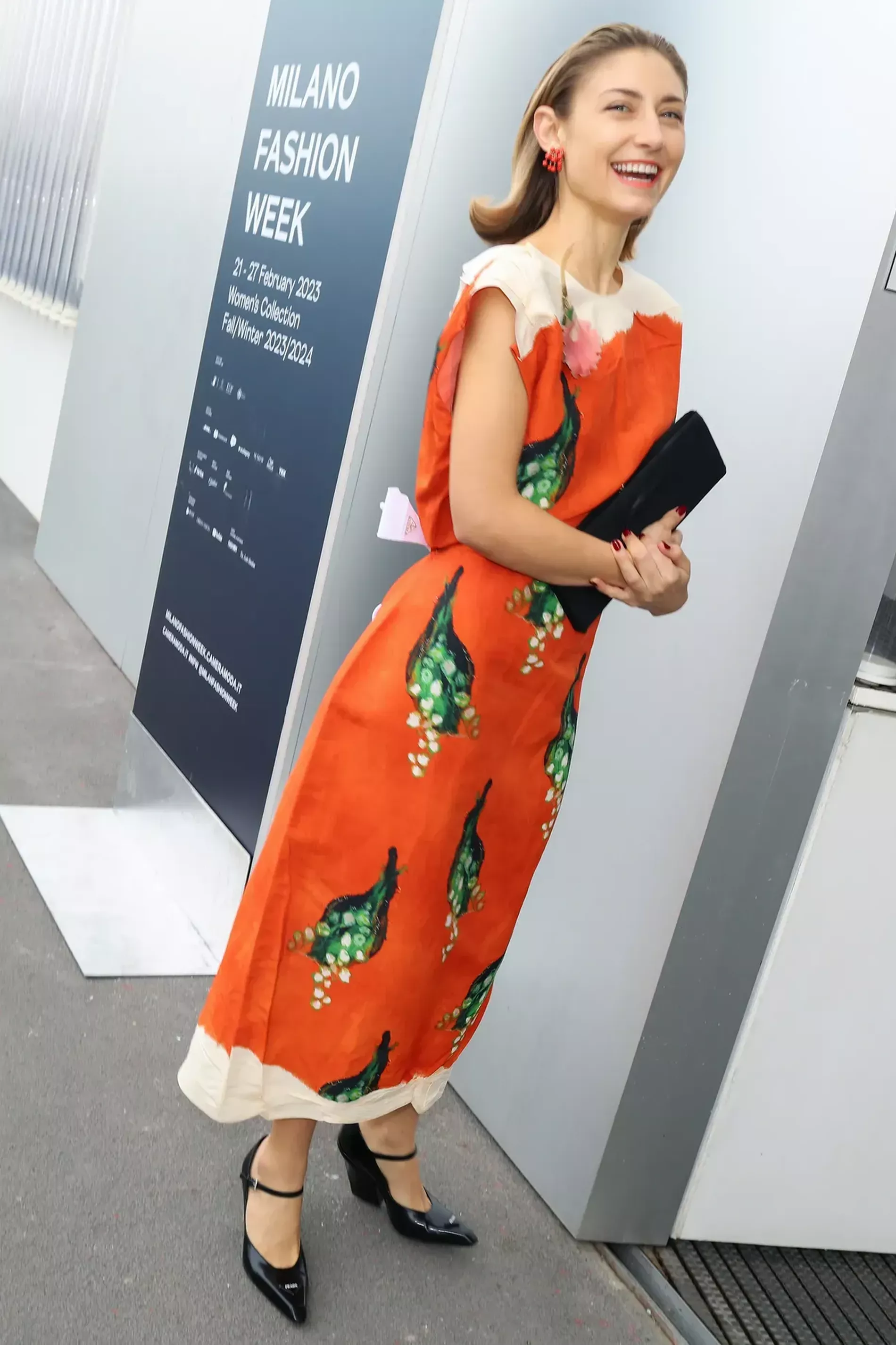 Milan fashion week guest wears orange glittery dress with black heels