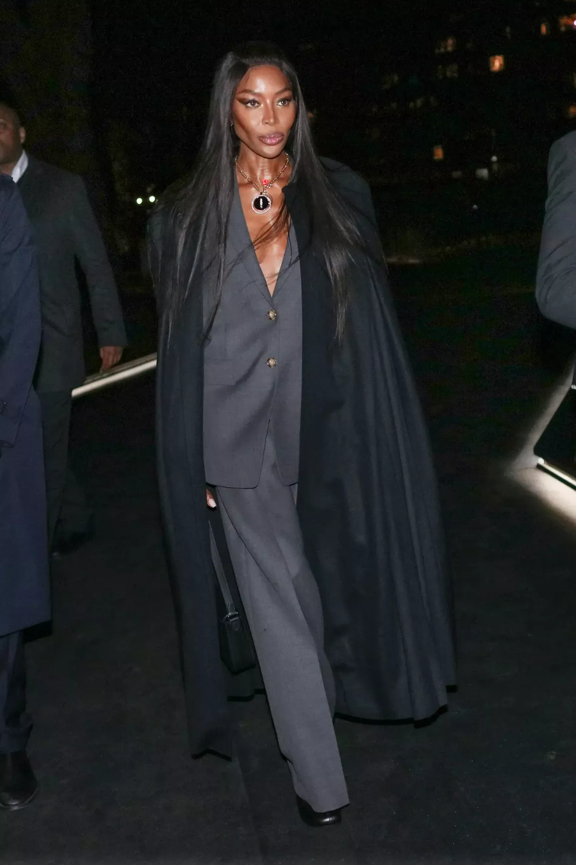 London fashion week guest wears dark grey suit over black coat 