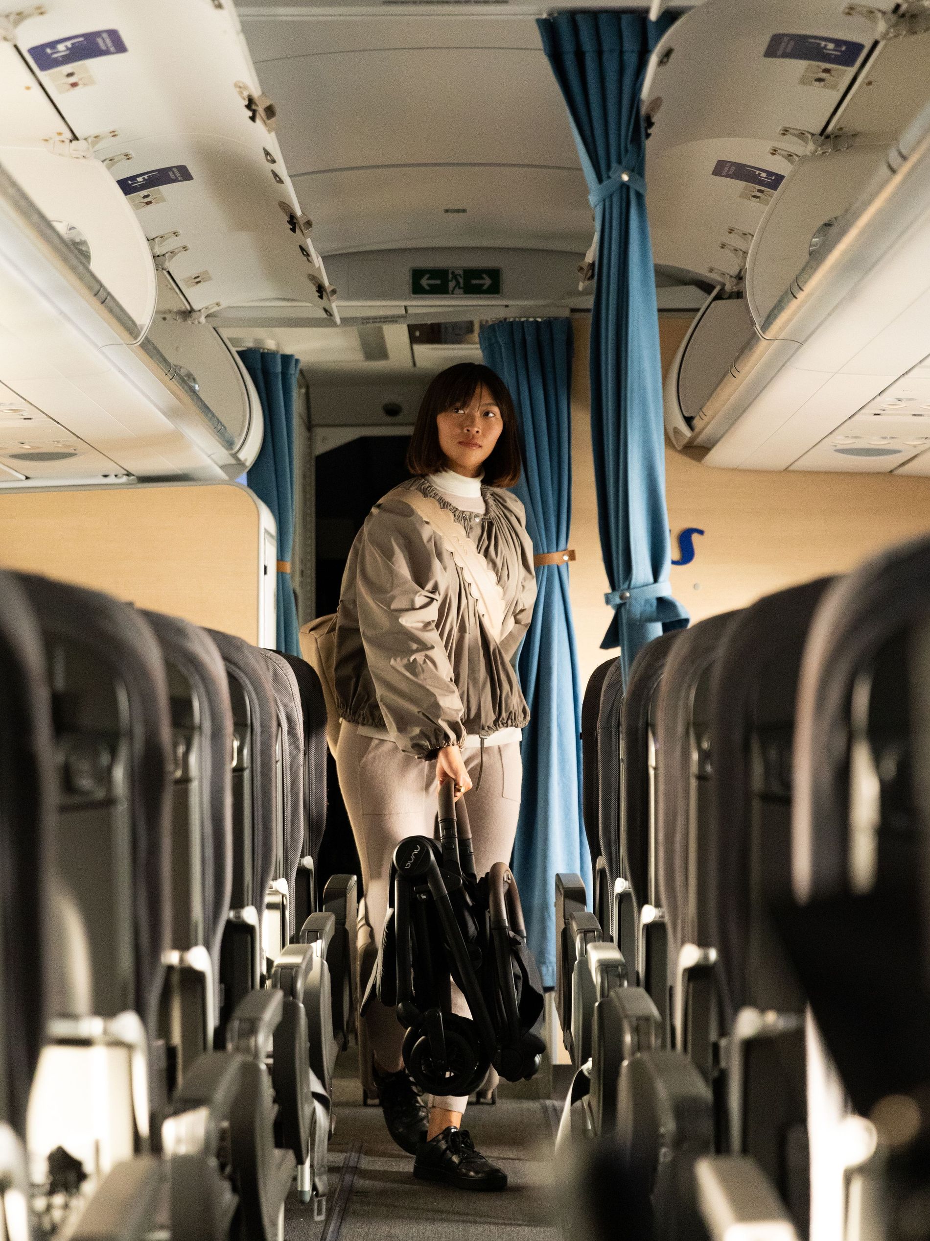 Woman carrying the Nuna VIAA cabn through the airplane