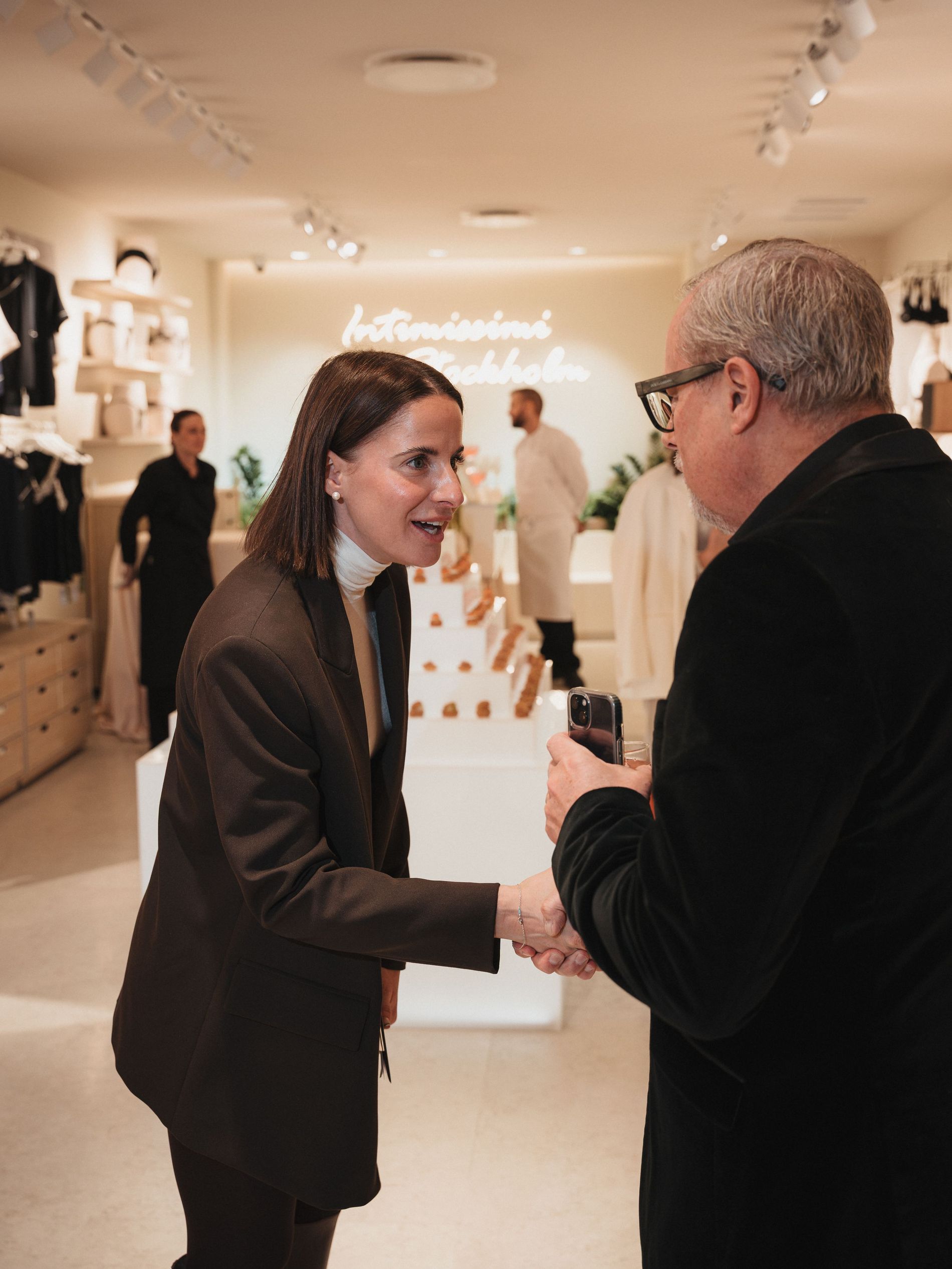 Two people at the intimissimi X Vogue Scandinavia event doing a handshake
