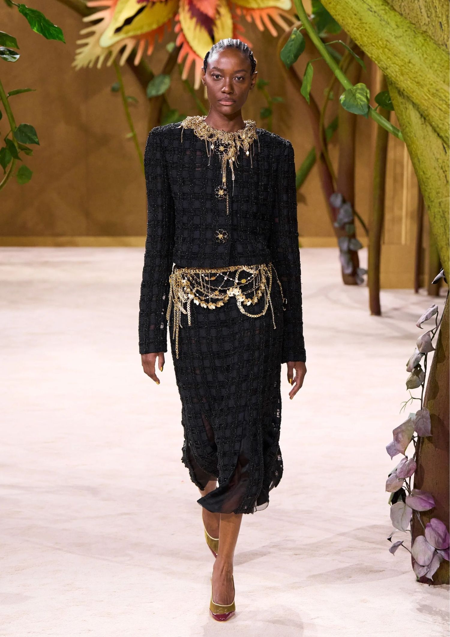 Black set consisting of a jacket and mid skirt, paired with gold jewllery