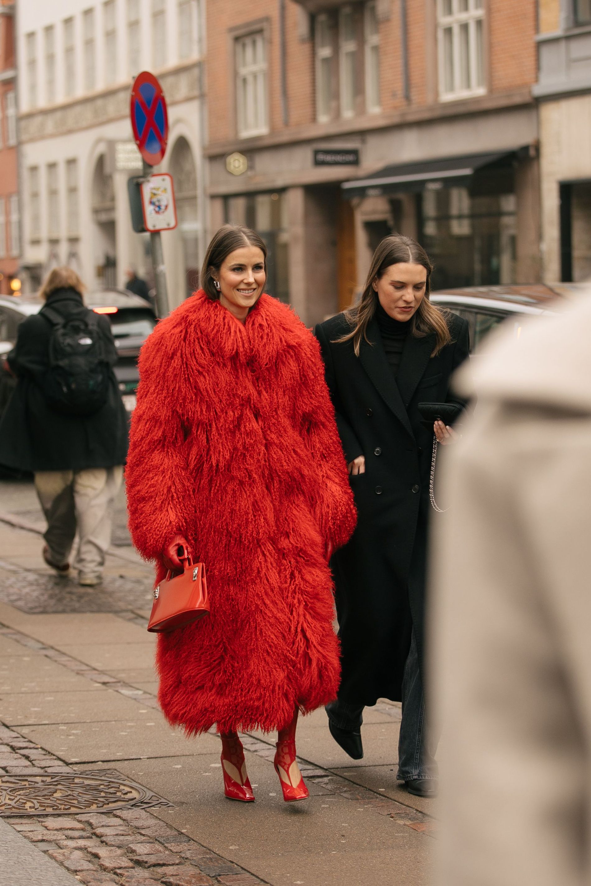 A guest at Copenhagen Fashion Week wears an all-red outfit featuring a faux fur coat
