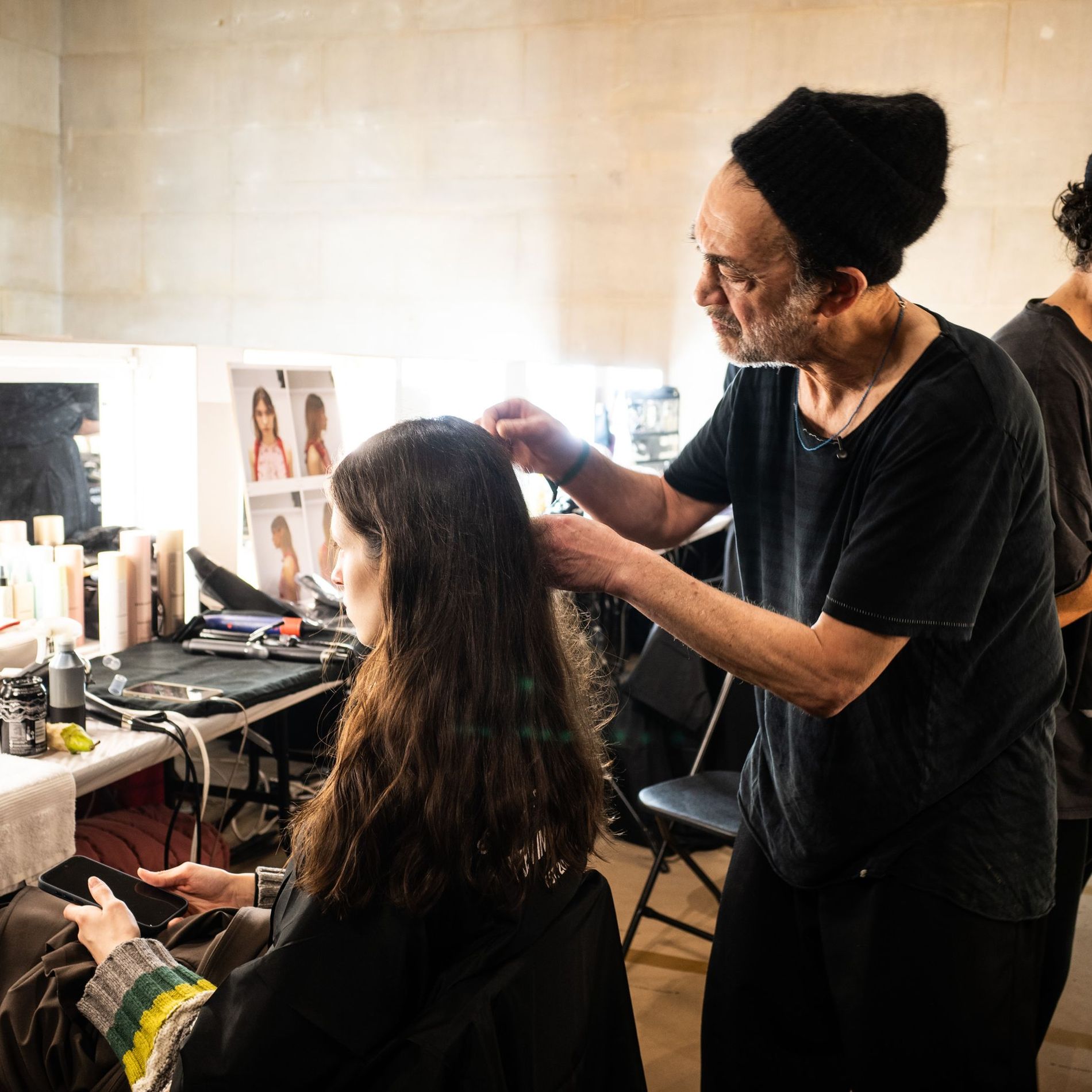 Celebrity hair stylist Eugene Souleiman preparing a model's hair backstage at Erdem